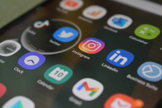 A close up of a cell phone with various social icons