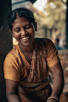 A woman sitting on the ground with a smile on her face