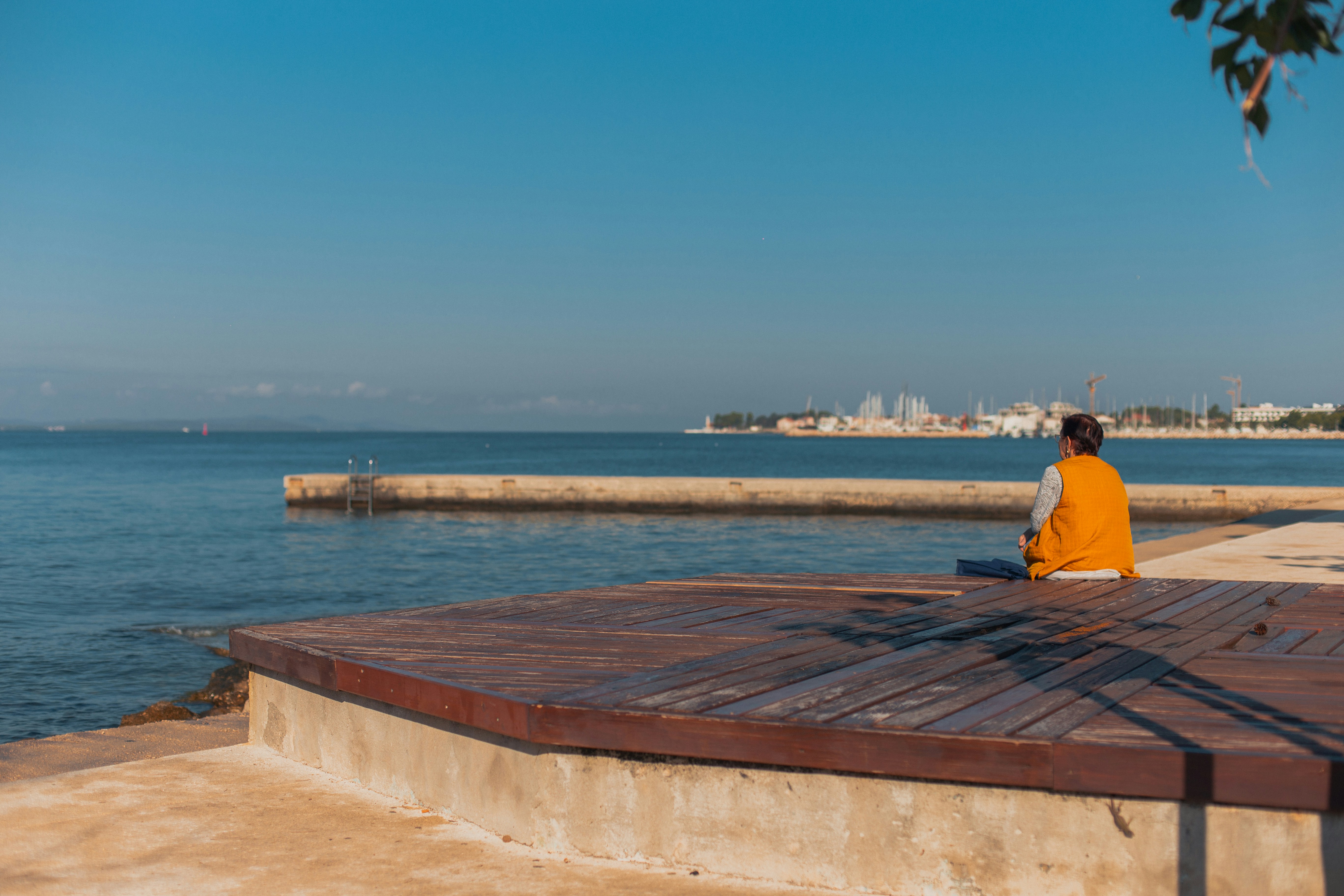 A person sitting on a bench near the water