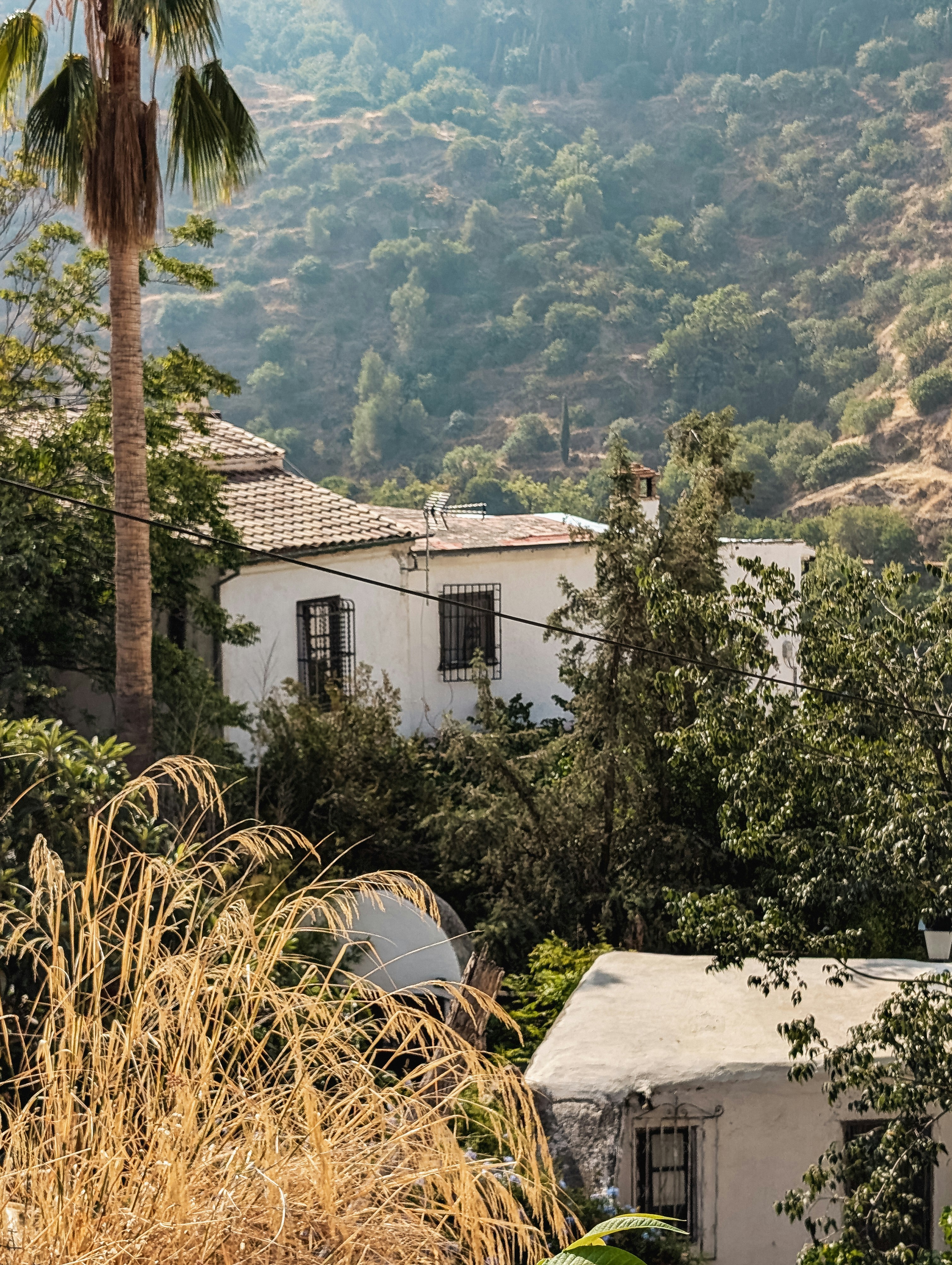A white house surrounded by trees and mountains