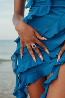 A woman in a blue dress with her hands on her hips