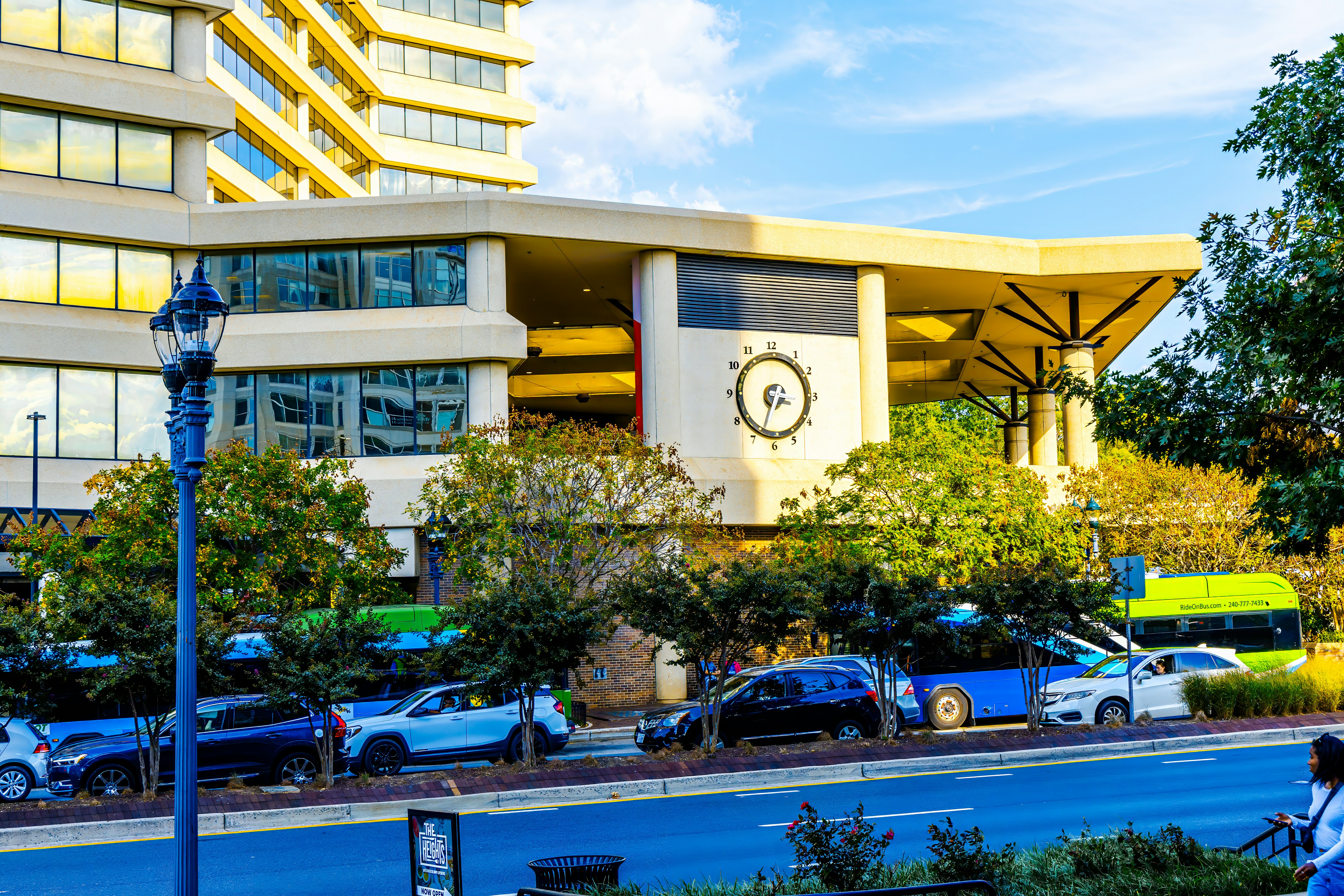 A woman riding a bike down a street next to a tall building
