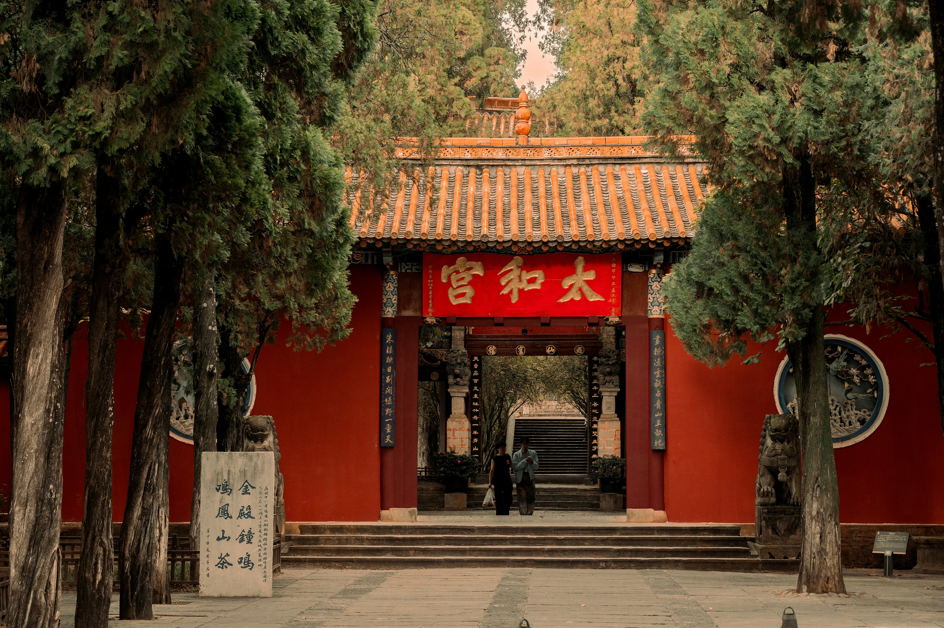 A red building surrounded by trees in a park