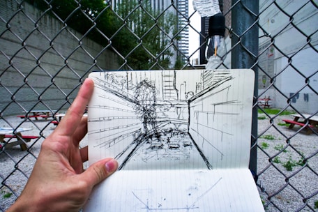 A person holding a piece of paper with a drawing on it