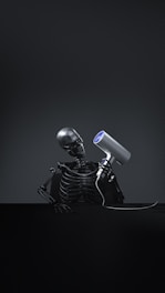 A skeleton with a hair dryer on its head