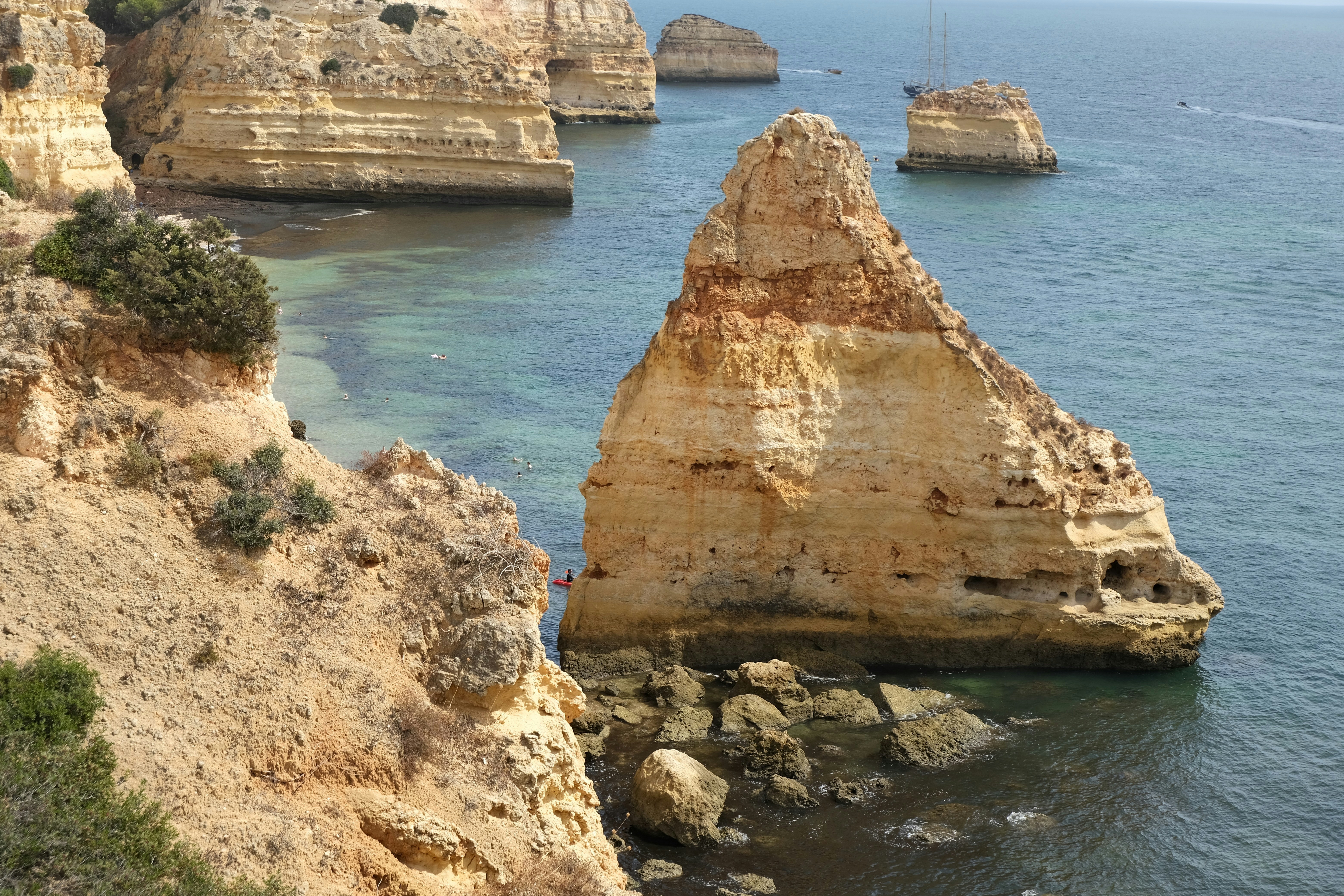 Yellow limestone cliffs and sea stack pictured along the seven hanging valleys trail near Praia da Marinha, Algarve, Portugal