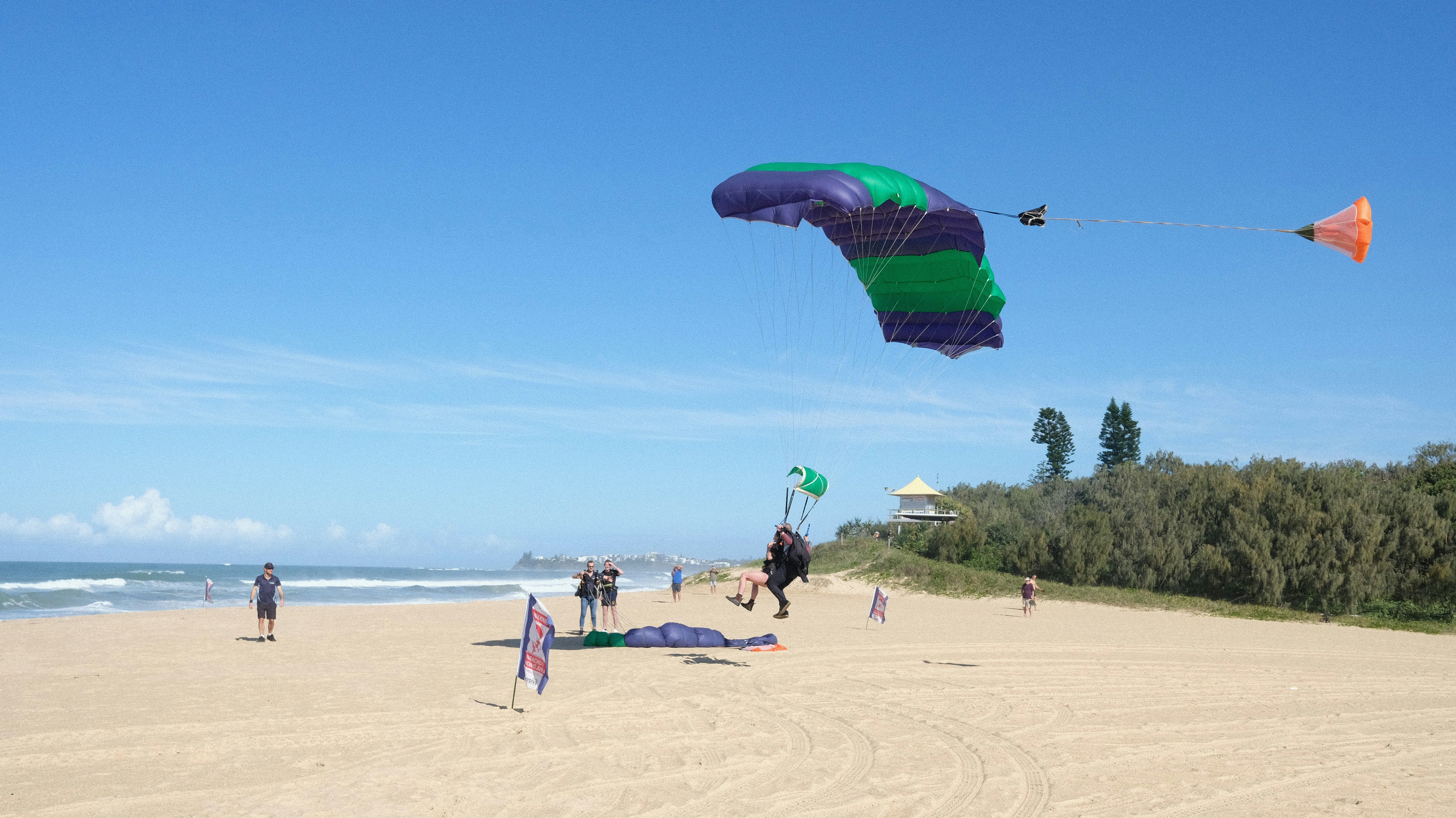 A group of people on a beach flying kites