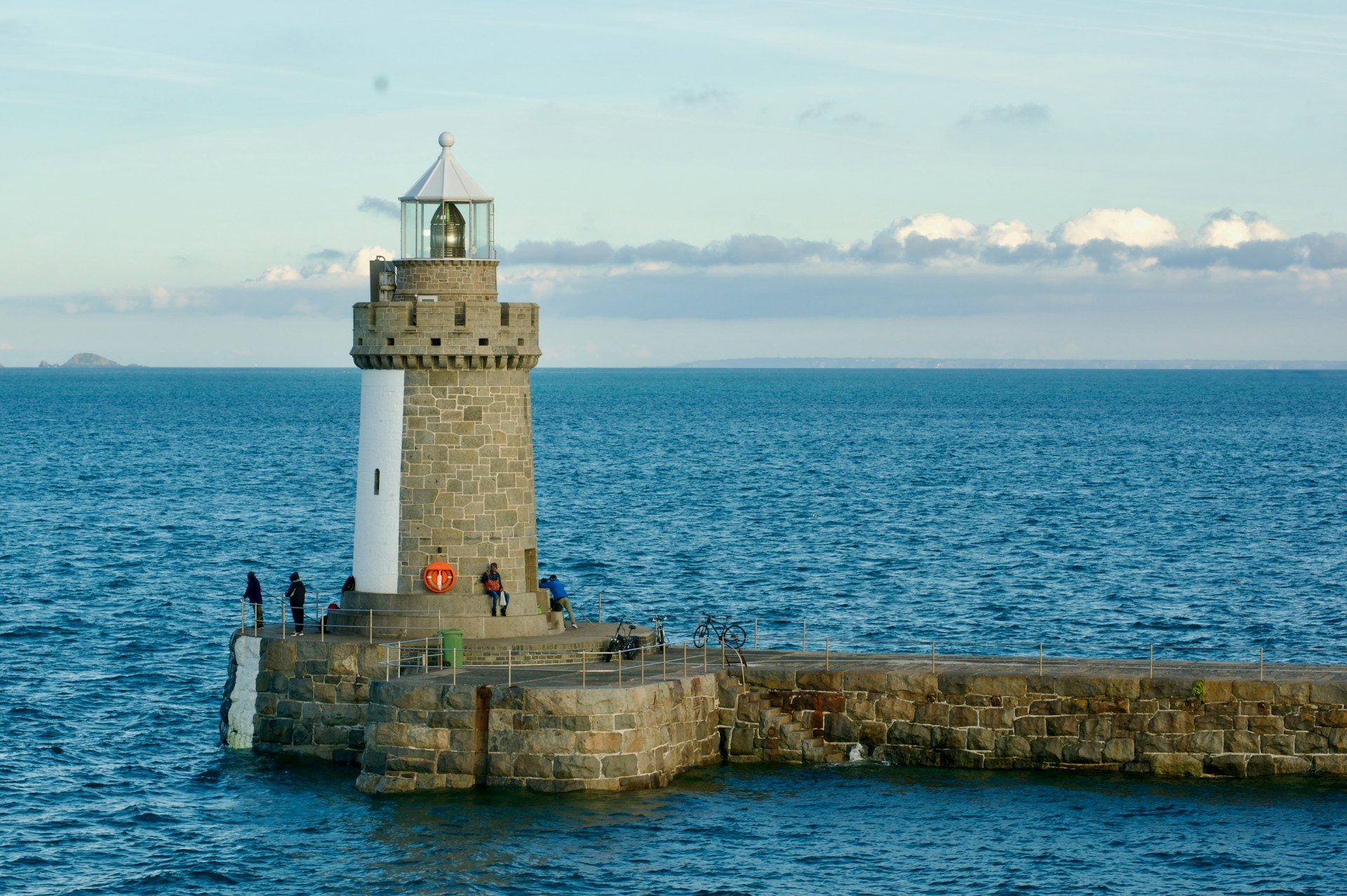 A light house sitting on top of a pier next to the ocean