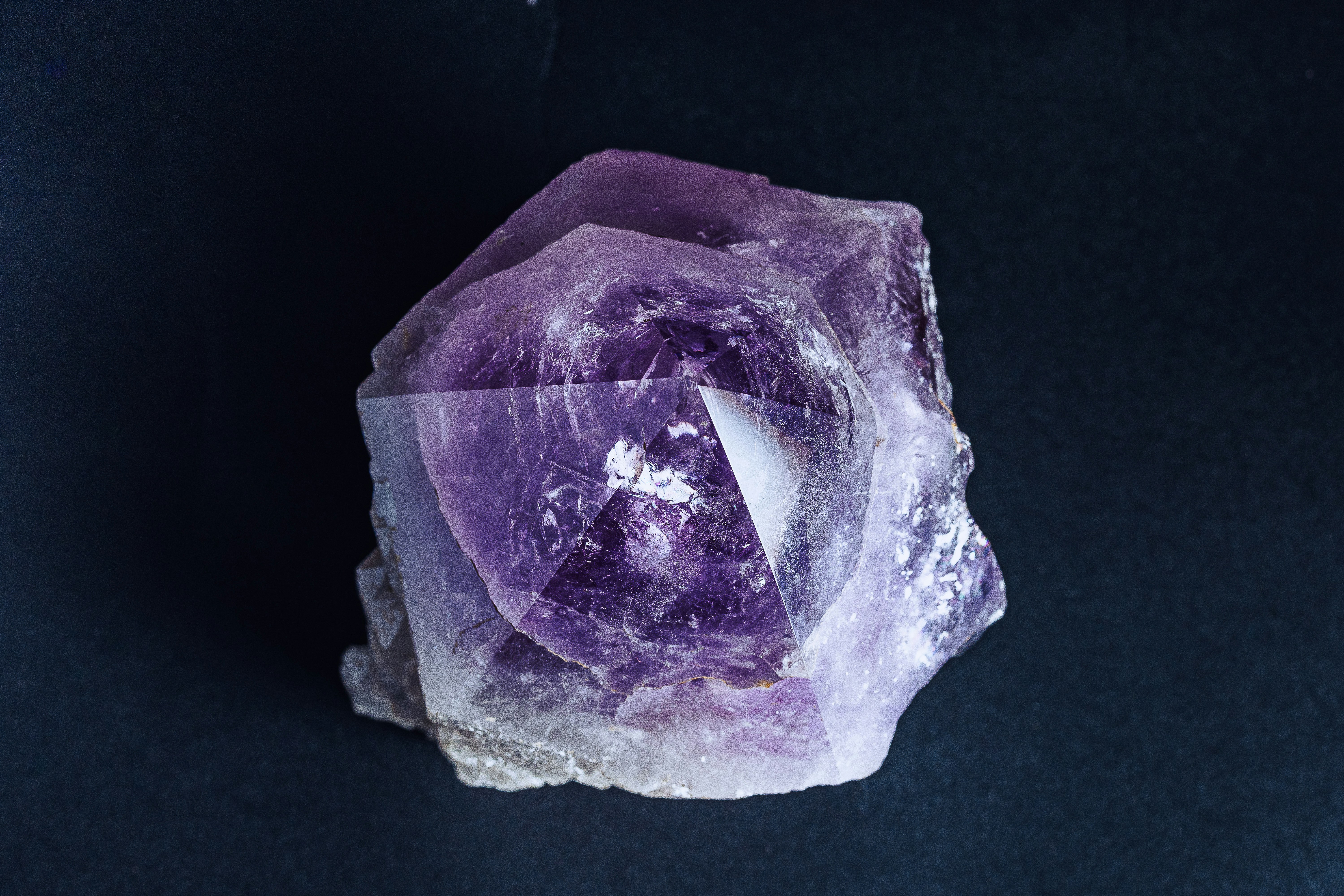 A purple rock sitting on top of a black surface