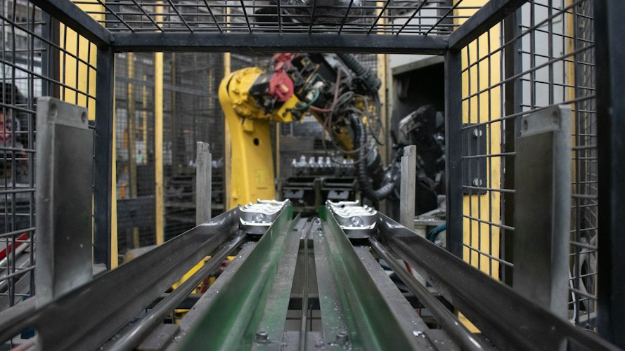 A robotic arm and conveyor belt system sorting packages by destination inside an automated distribution center