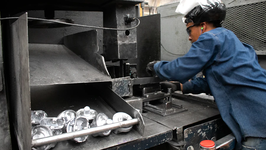 Machinist operating a CNC lathe on large steel workpieces in a metalworking shop