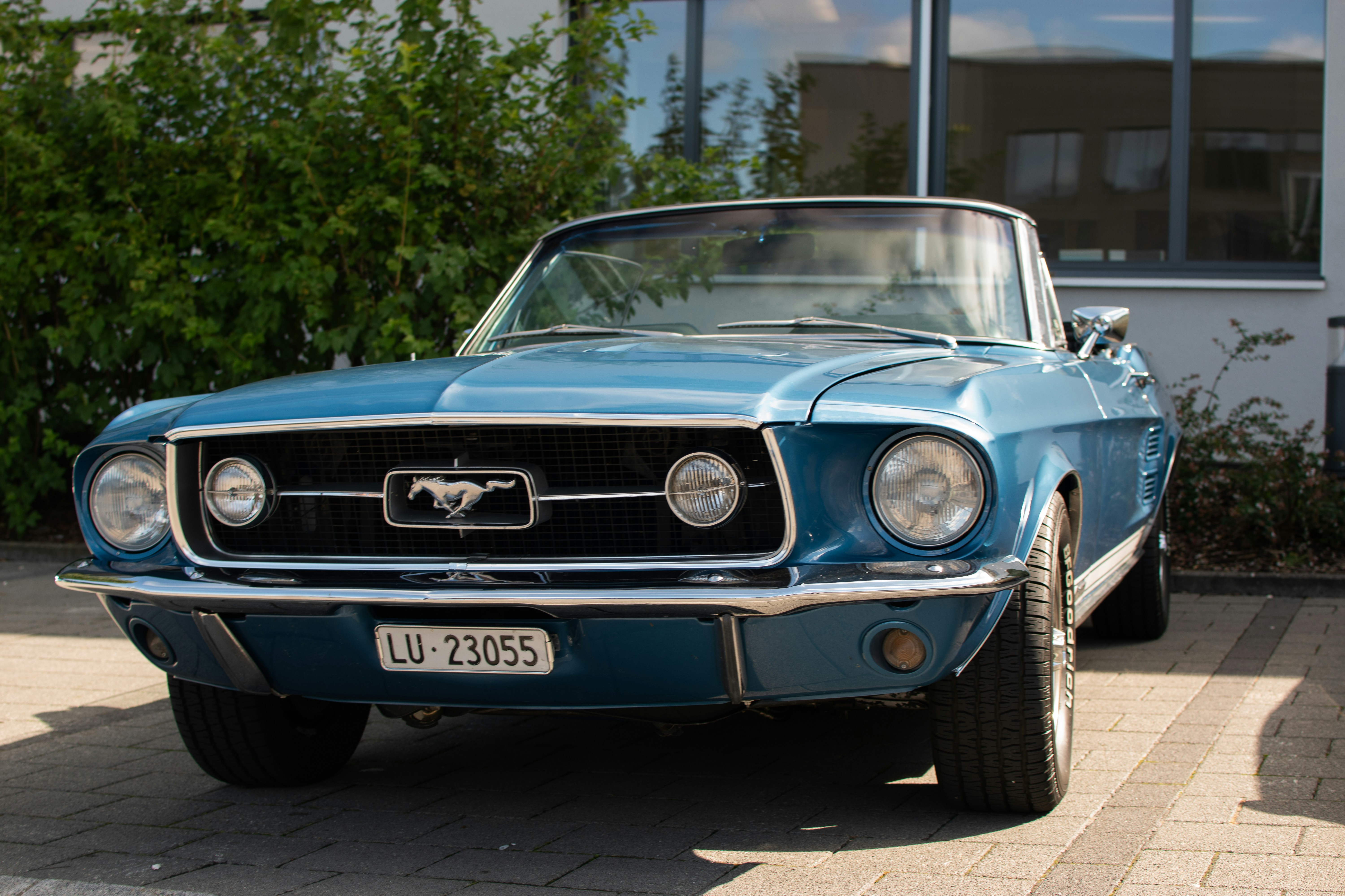 Ein blauer Mustang, der vor einem Gebäude geparkt ist