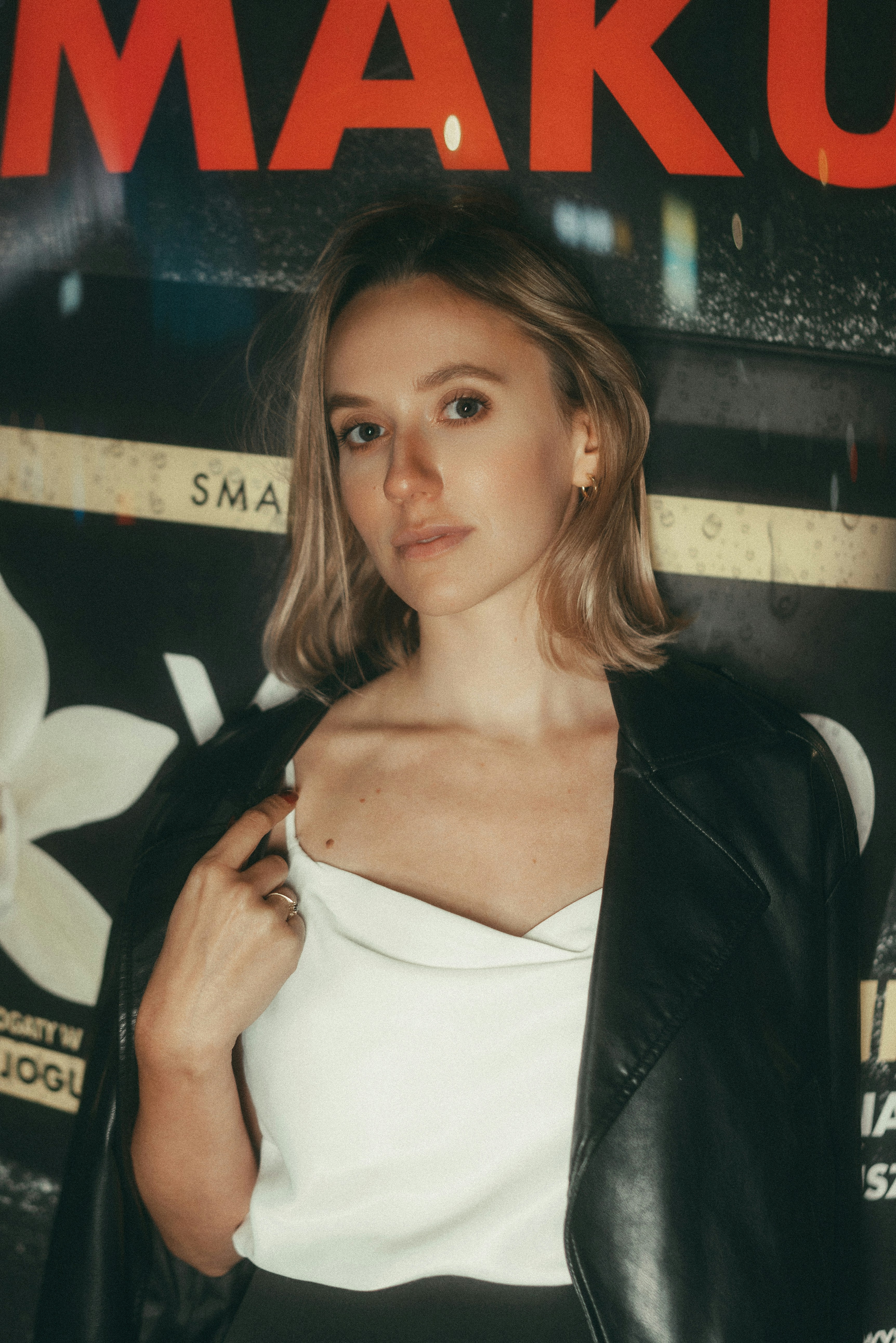 A woman posing for a picture in front of a poster