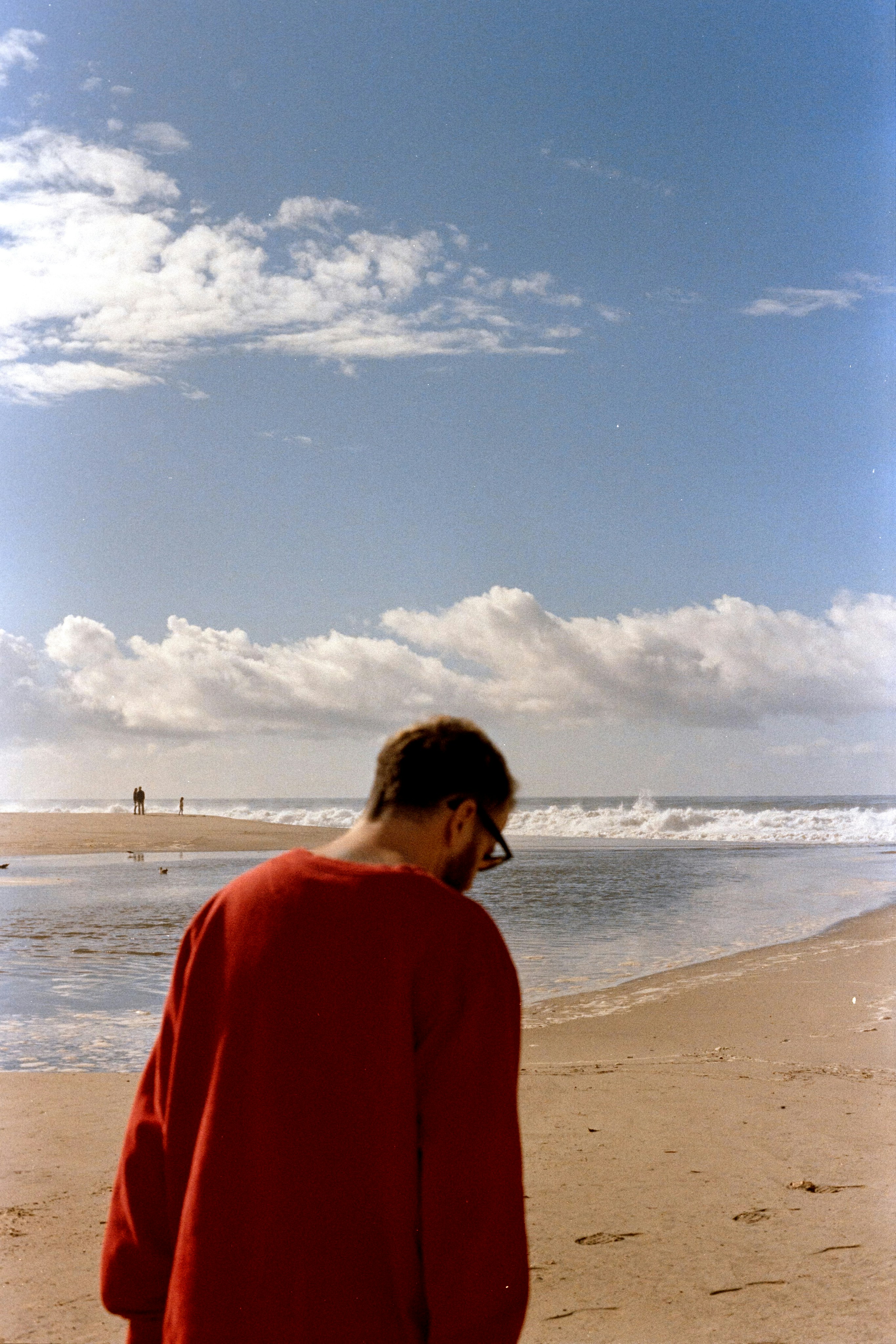 A man standing on a beach looking at the ocean photo – Free Beach Image ...