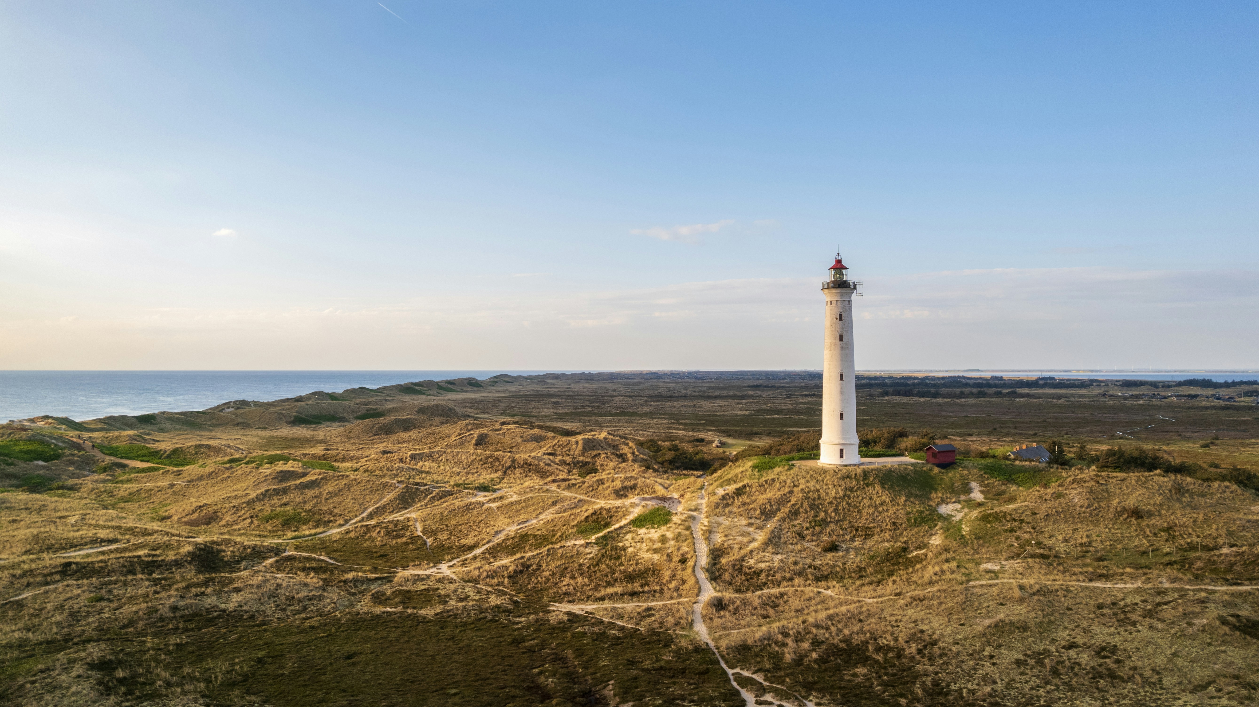 A light house on a small island in the middle of the ocean