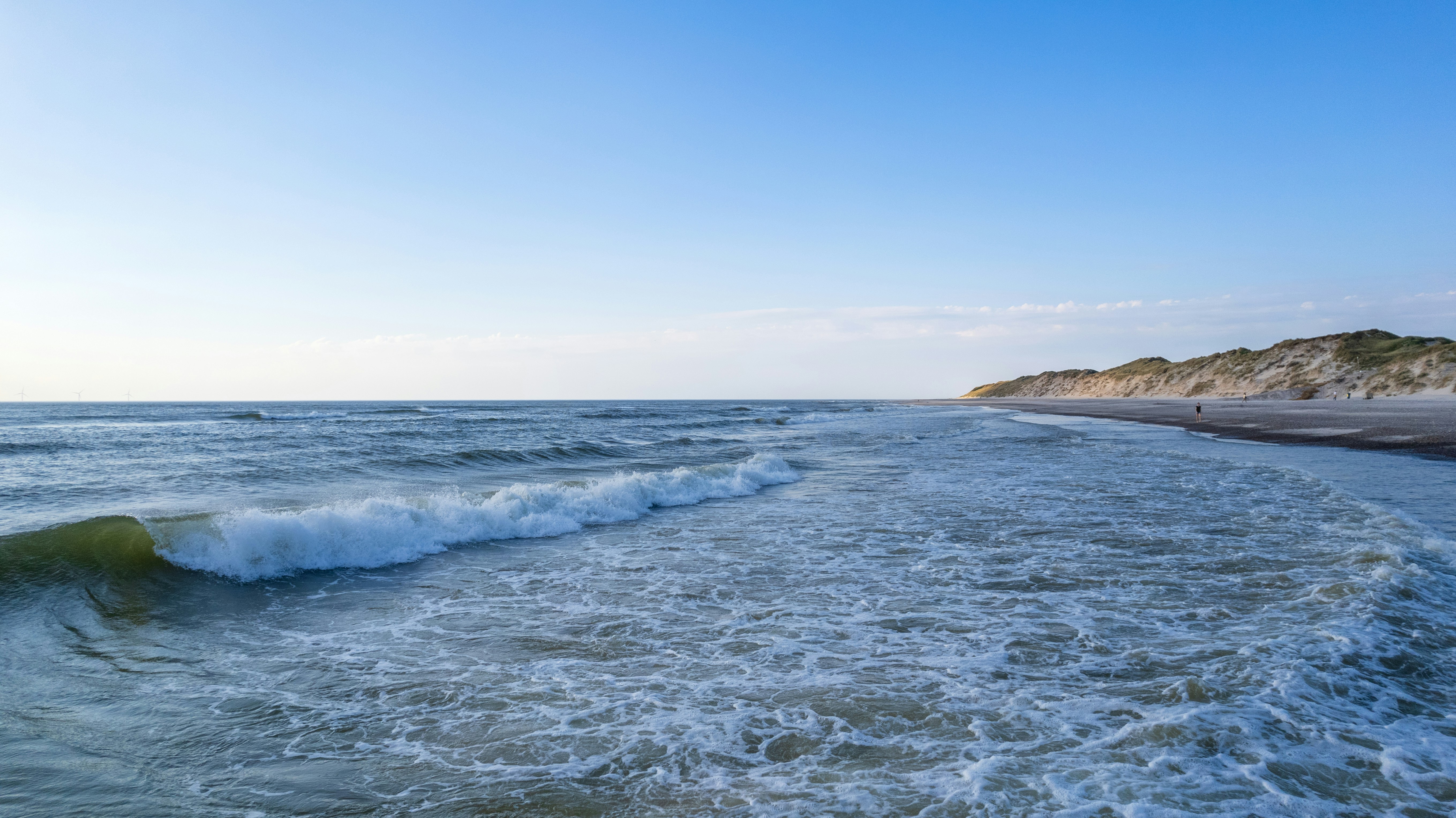 A view of a beach with waves coming in to shore