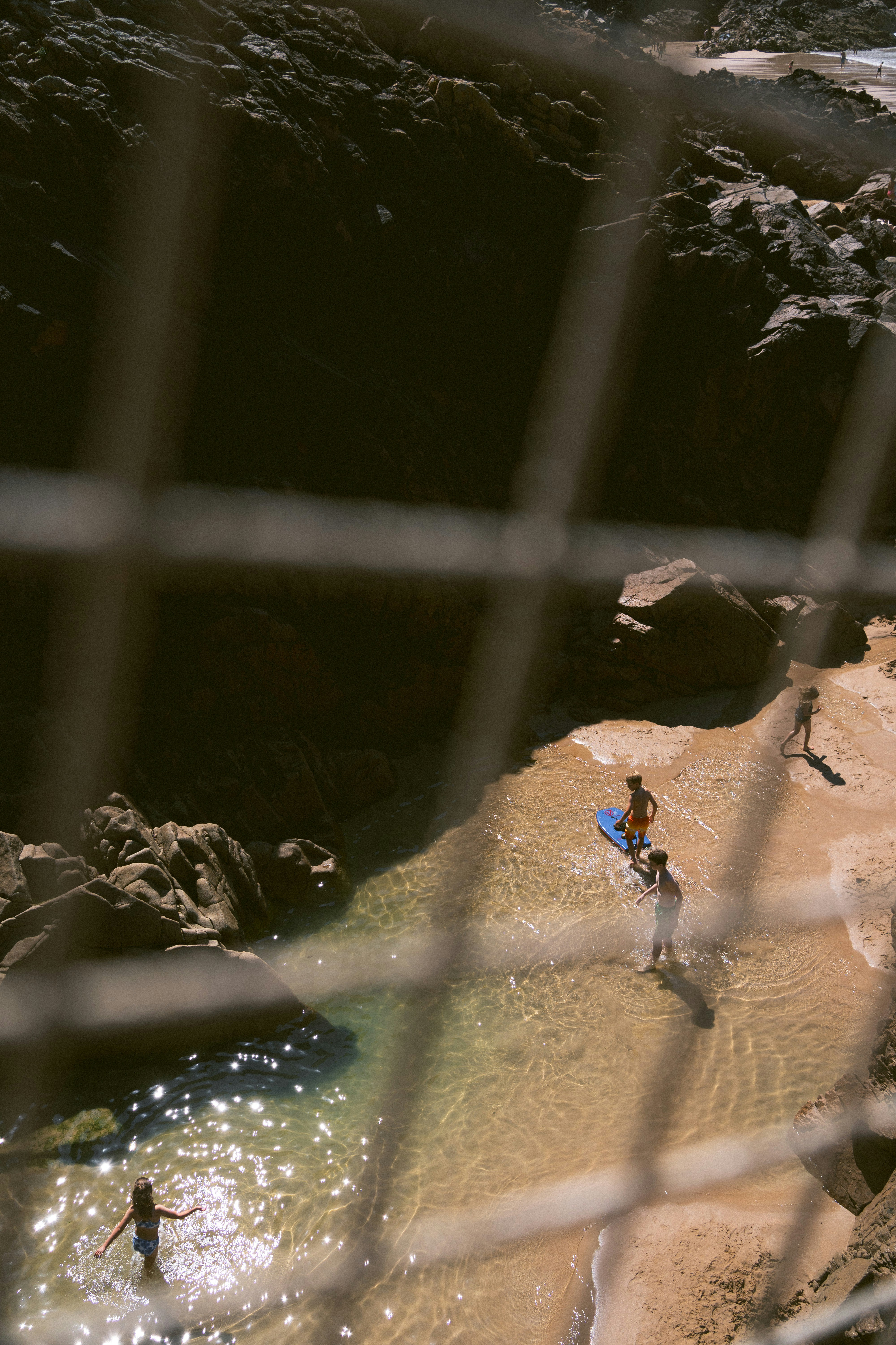 A group of people standing on top of a sandy beach