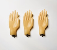 Three yellow plastic gloves on a white surface