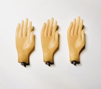 Three yellow plastic gloves on a white surface