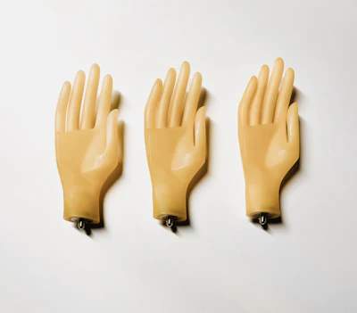 Three mannequin hands on a white wall