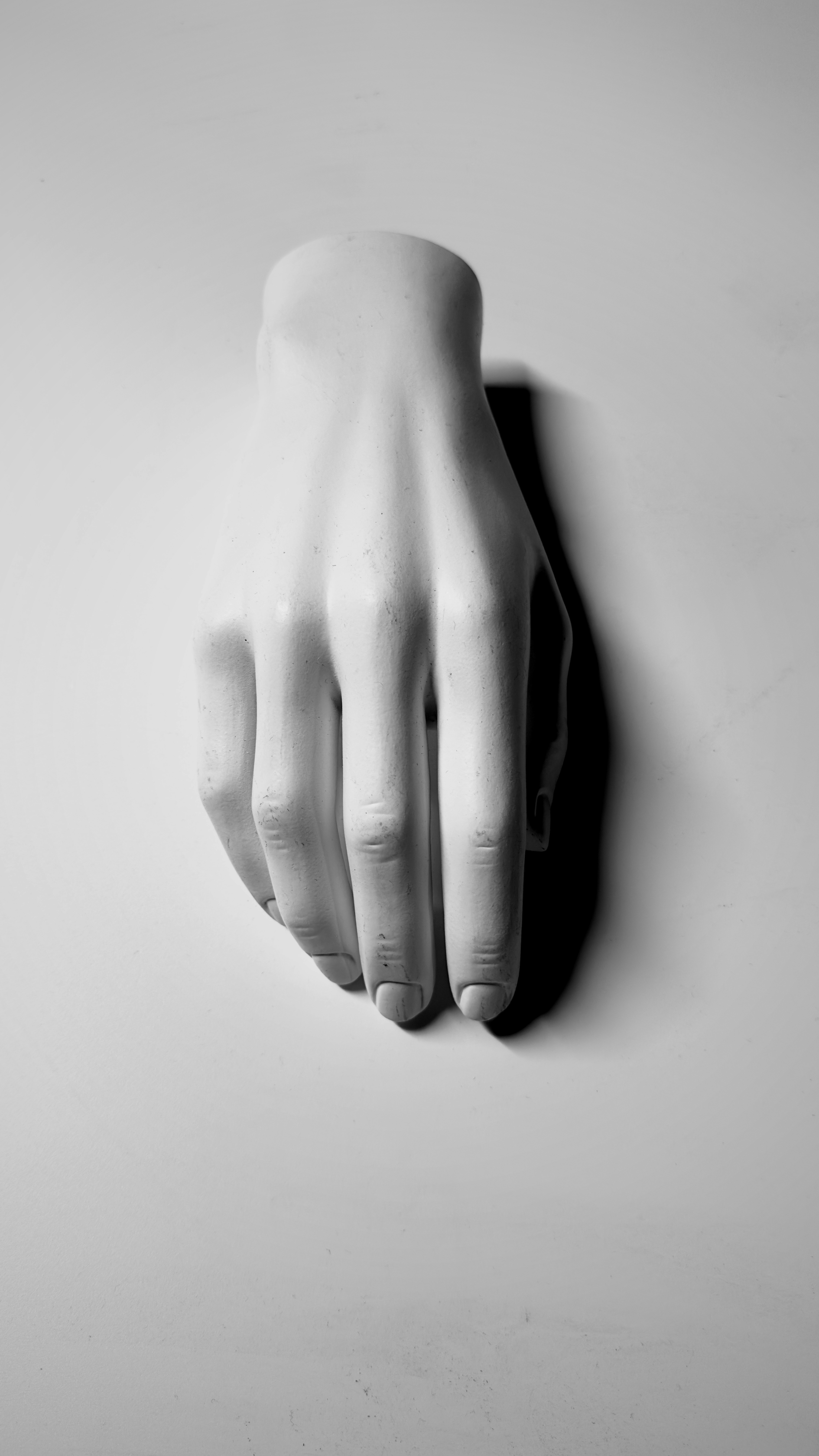 A black and white photo of a hand on a wall