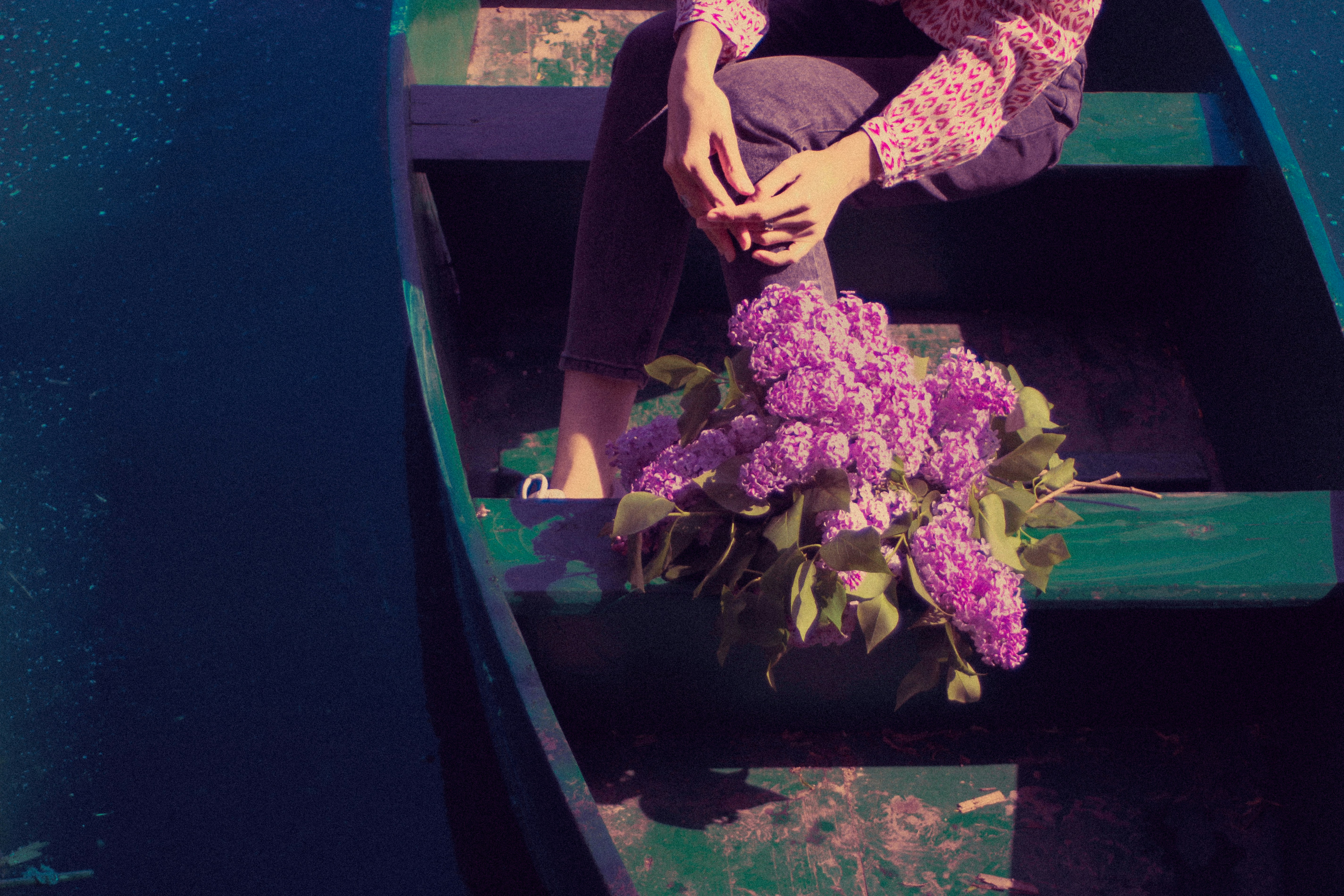 Eine Frau, die in einem Boot mit lila Blumen sitzt