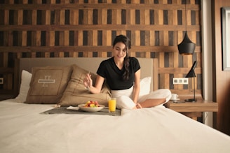 A woman sitting on a bed in a hotel room