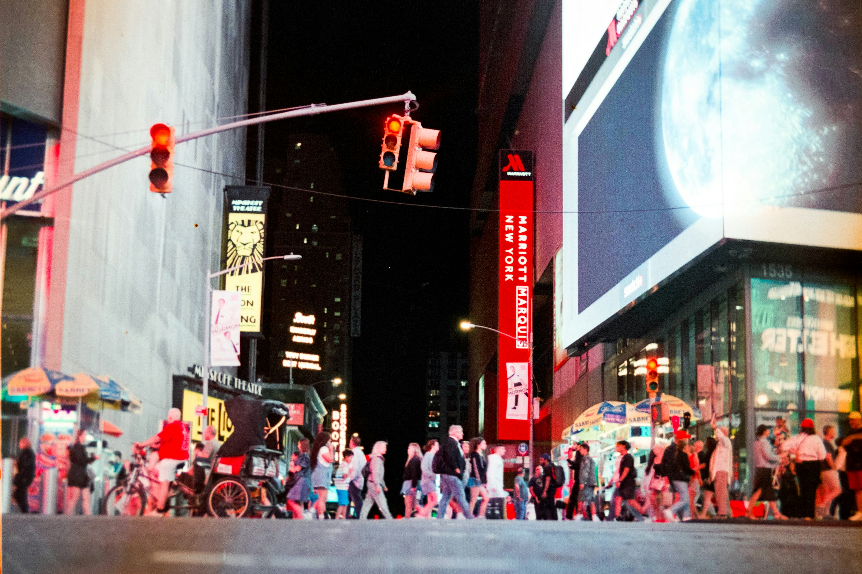 Busy street scene with people crossing at night