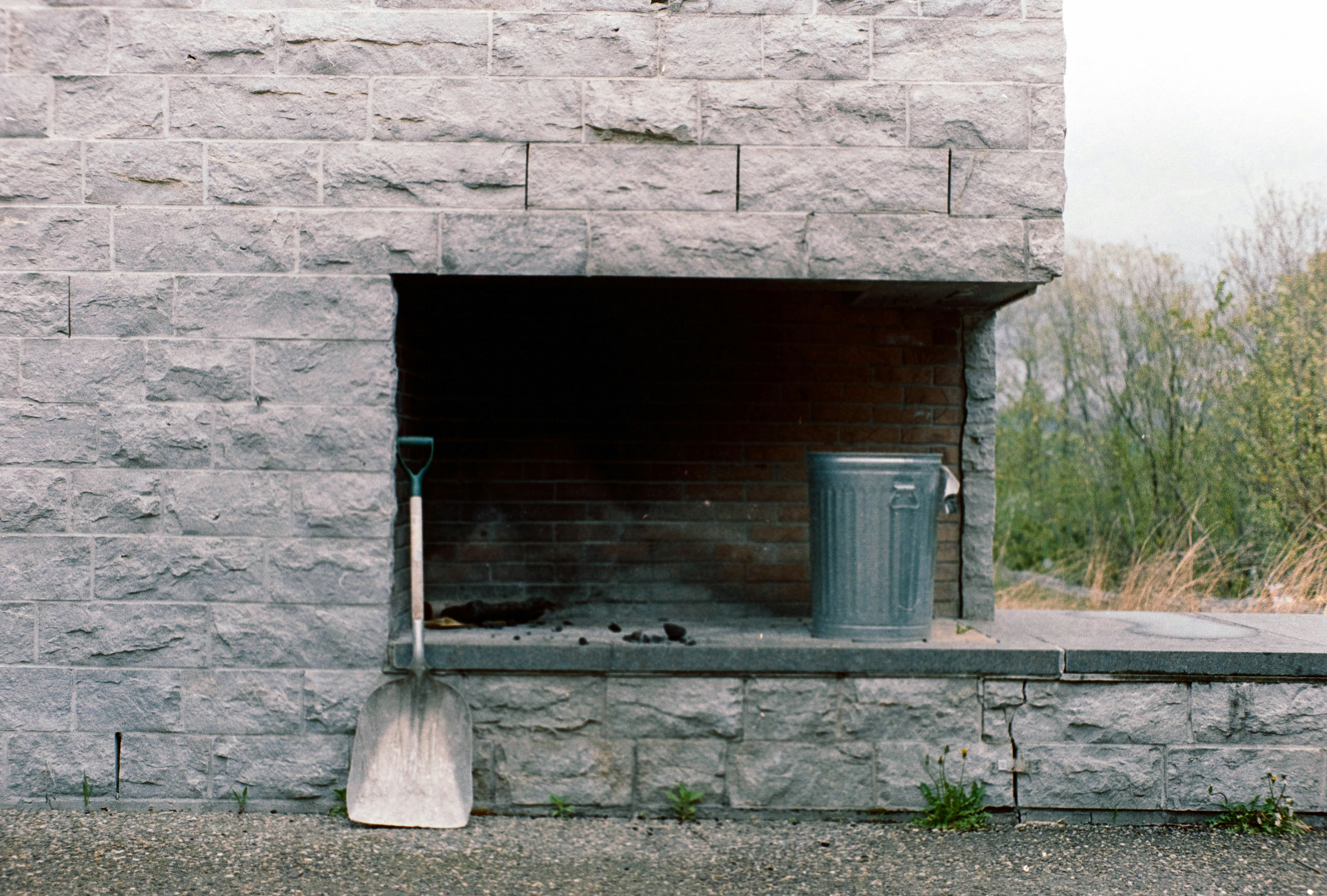 A fire place with a trash can and a trash can next to it