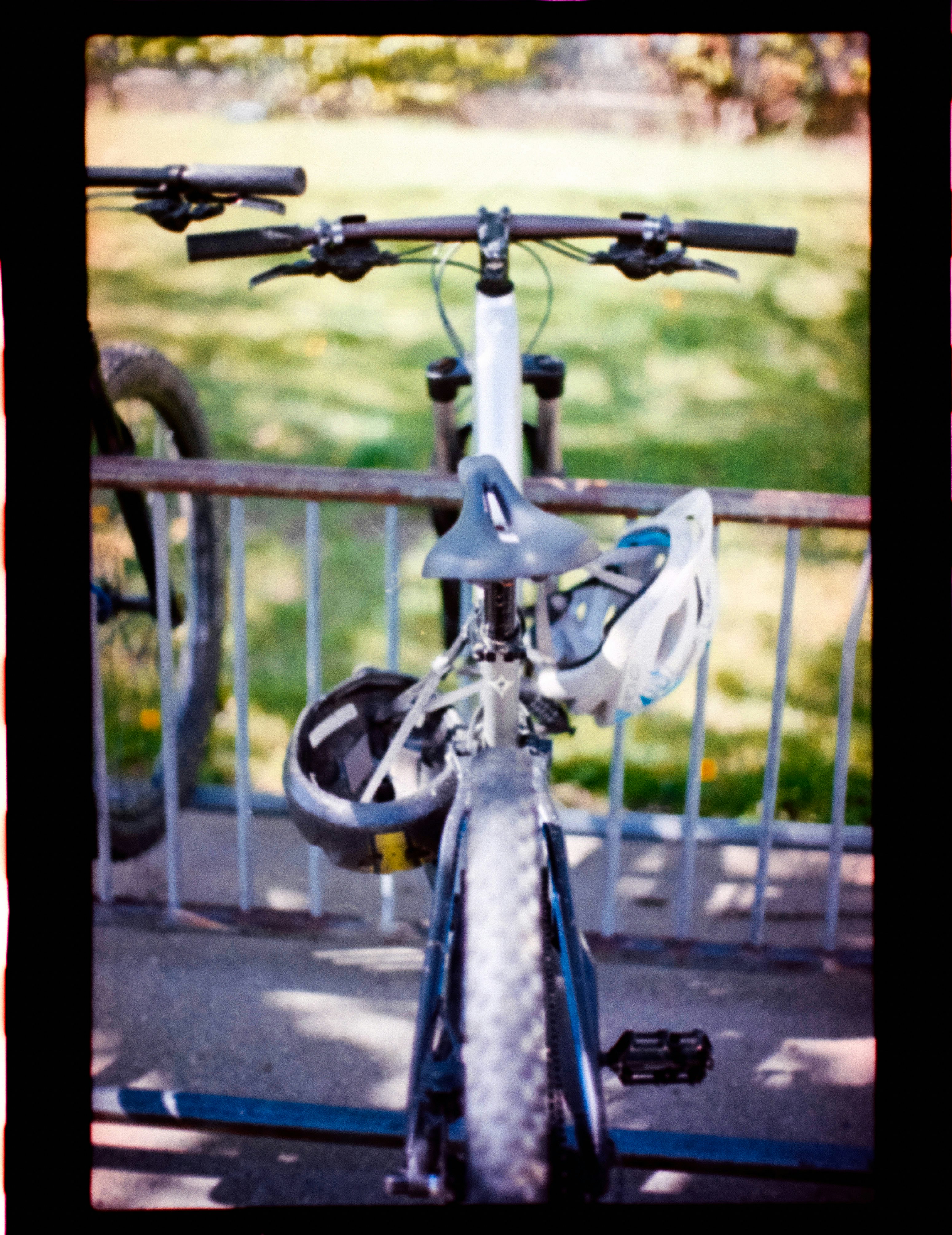 Two bicycles parked with helmets attached