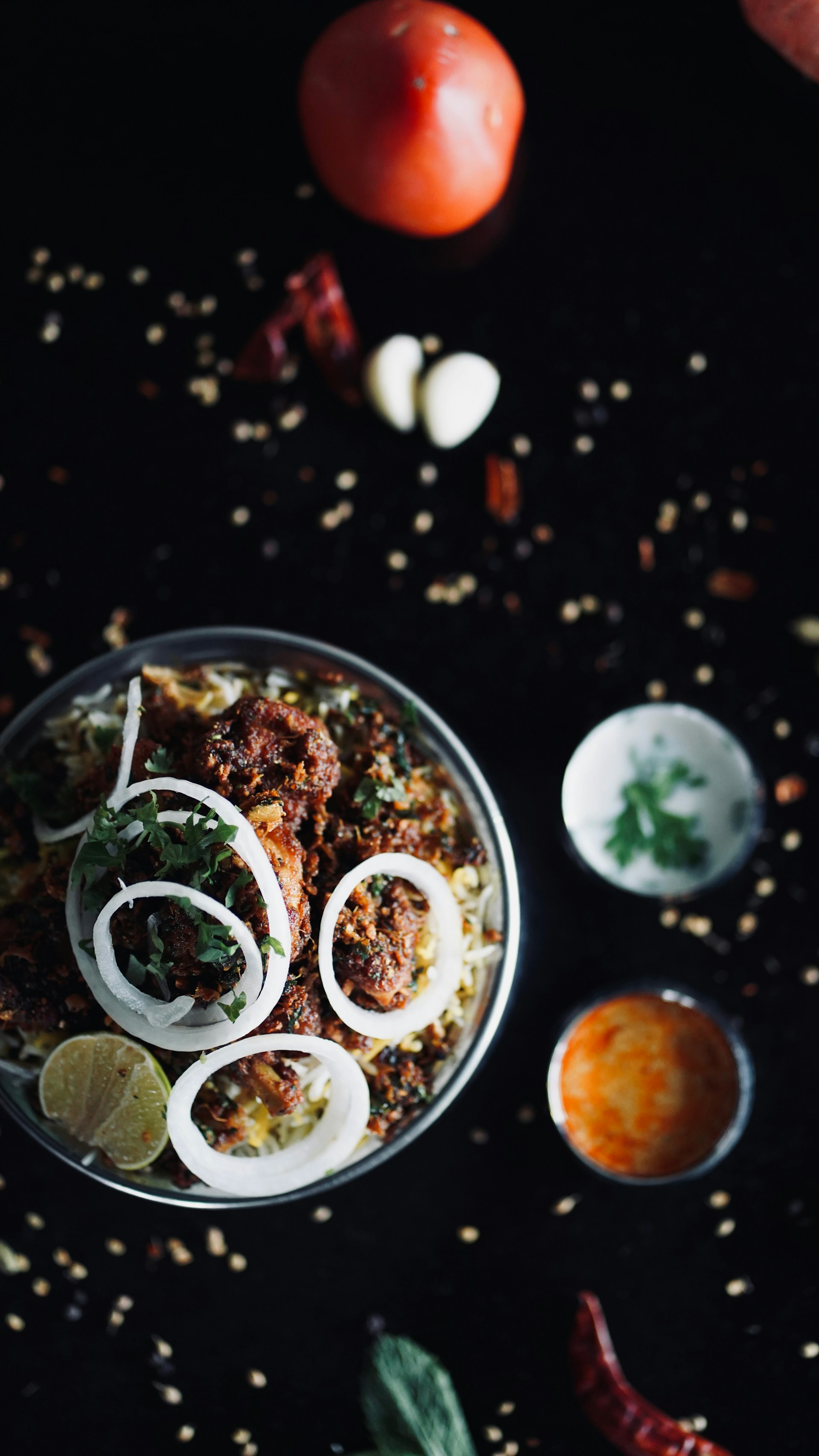 A bowl of food with onions, tomatoes and other ingredients