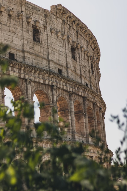 A close up of a very old building with trees in front of it