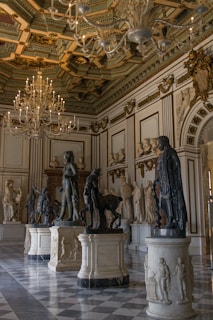 A room with statues and chandeliers in it