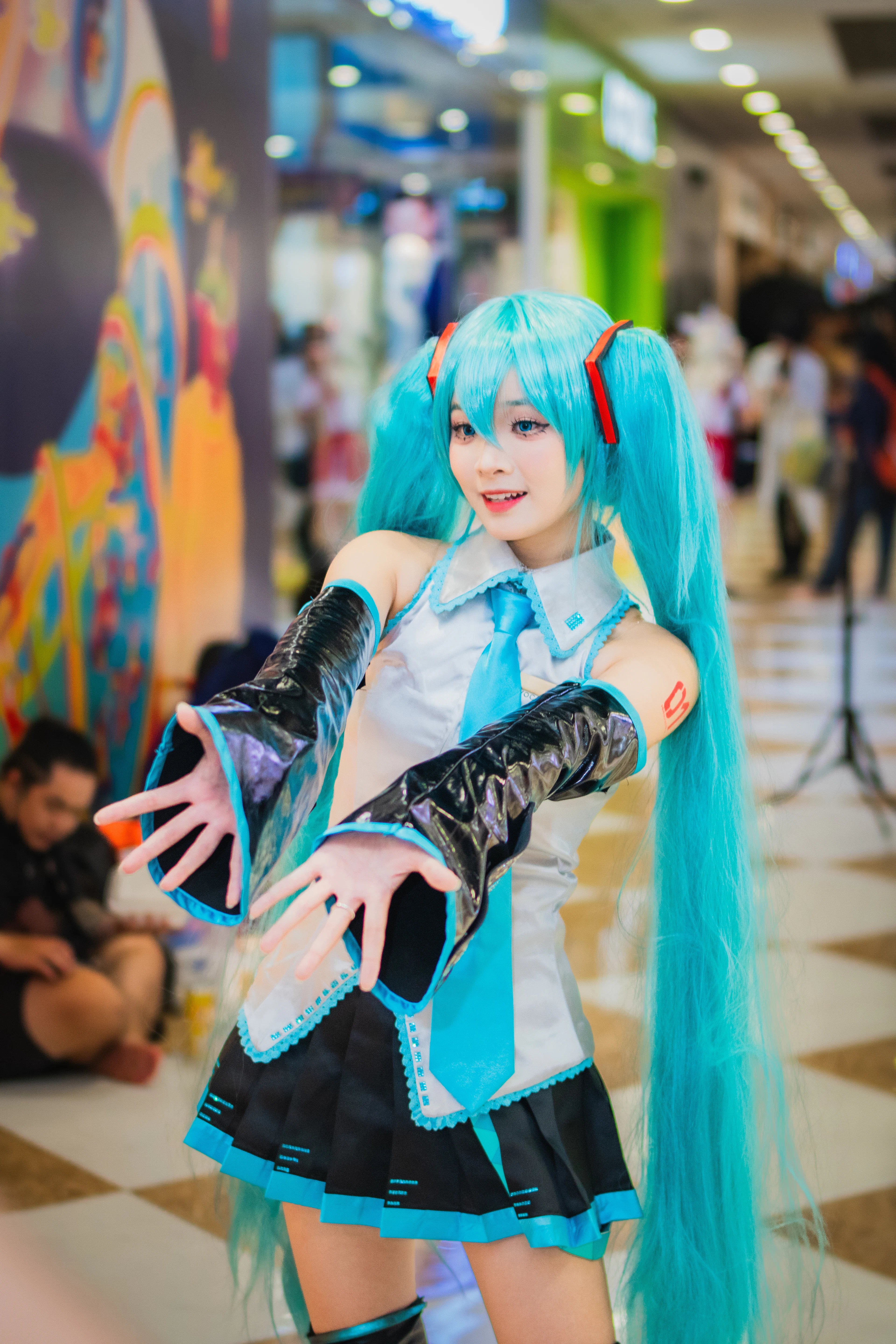 Cosplayeuse aux longues couettes bleues posant pour une photo