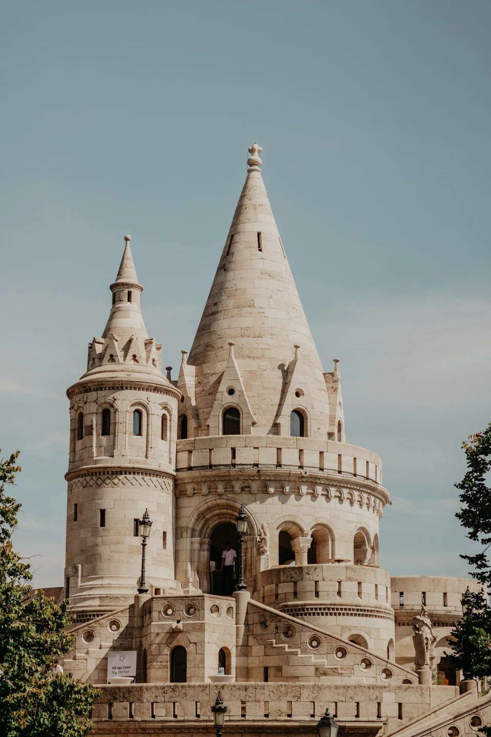 Majestic stone castle perched atop a hill with multiple towers and spires reaching towards sky