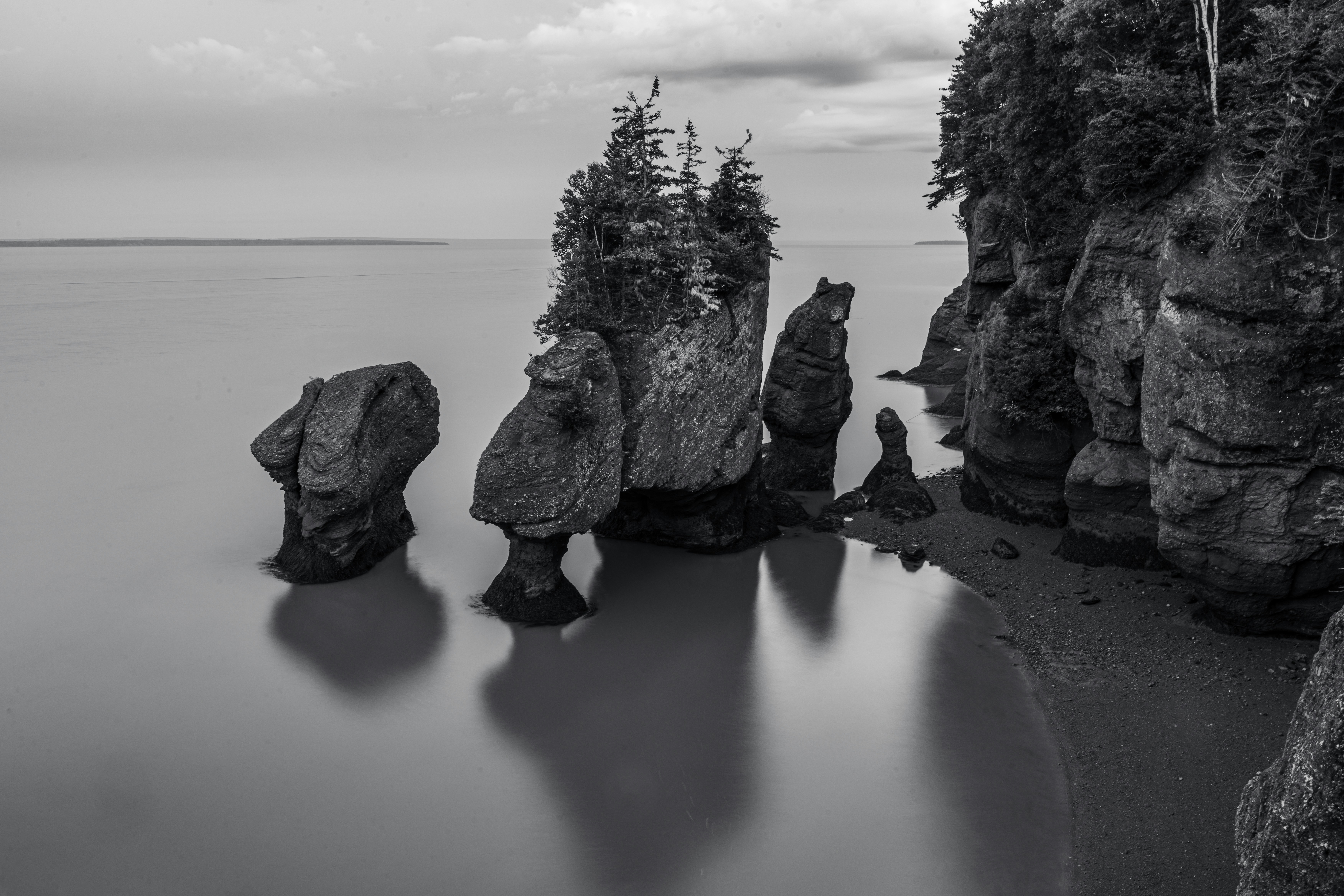 A black and white photo of some rocks in the water