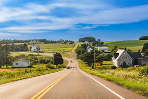 A country road with houses and fields in the background