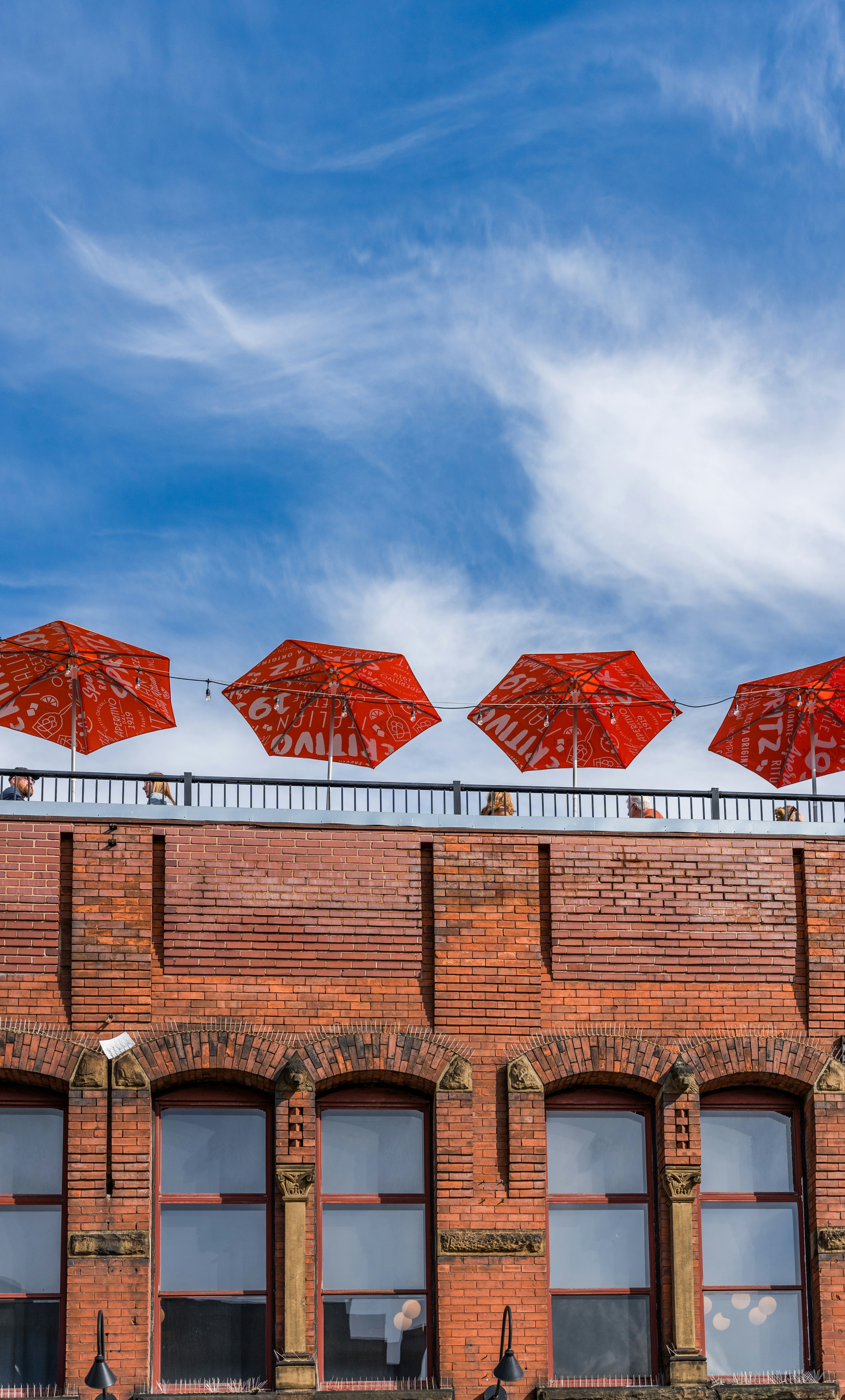 A row of red umbrellas sitting on top of a building
