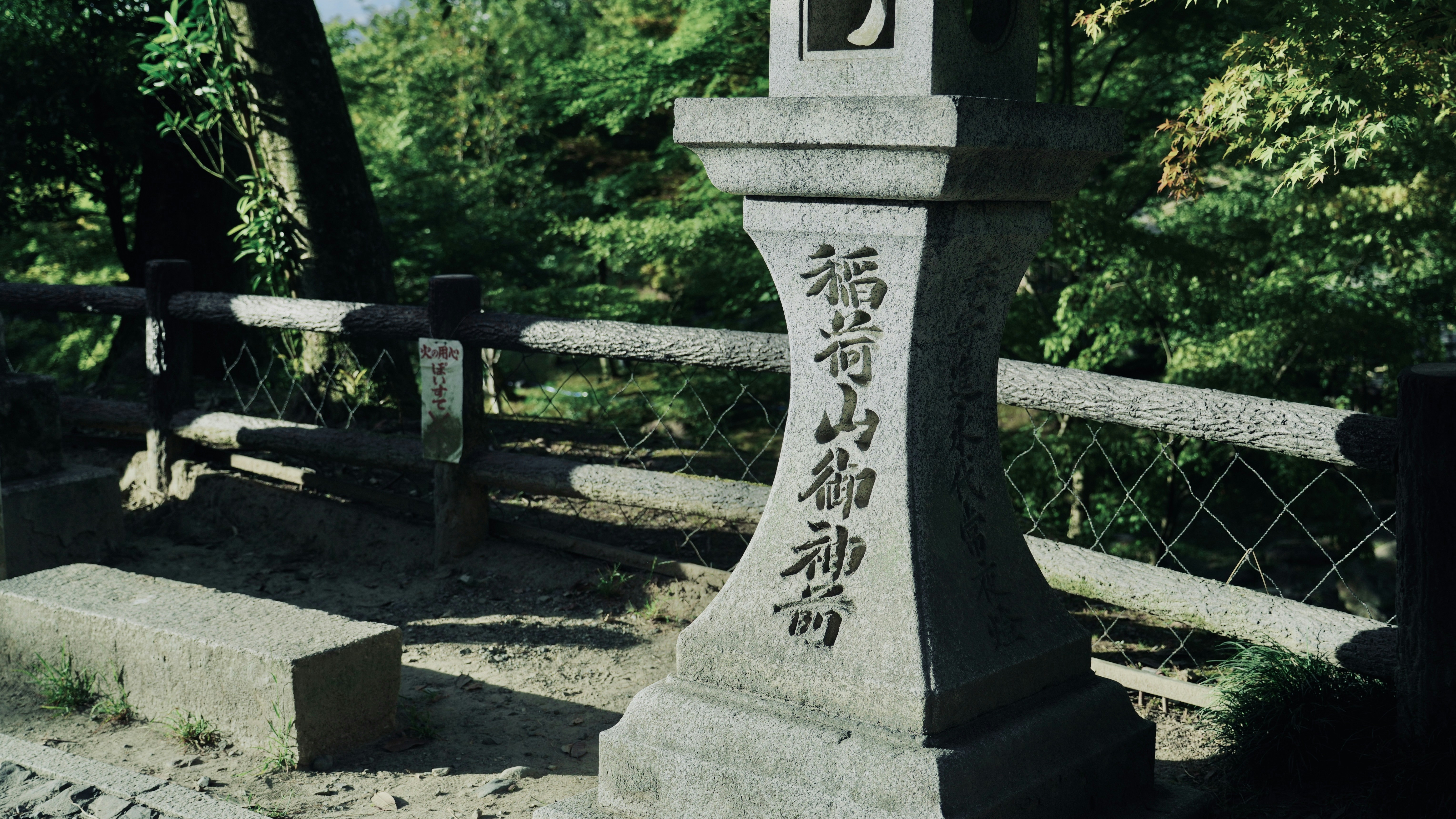 A stone lantern in a park with trees in the background