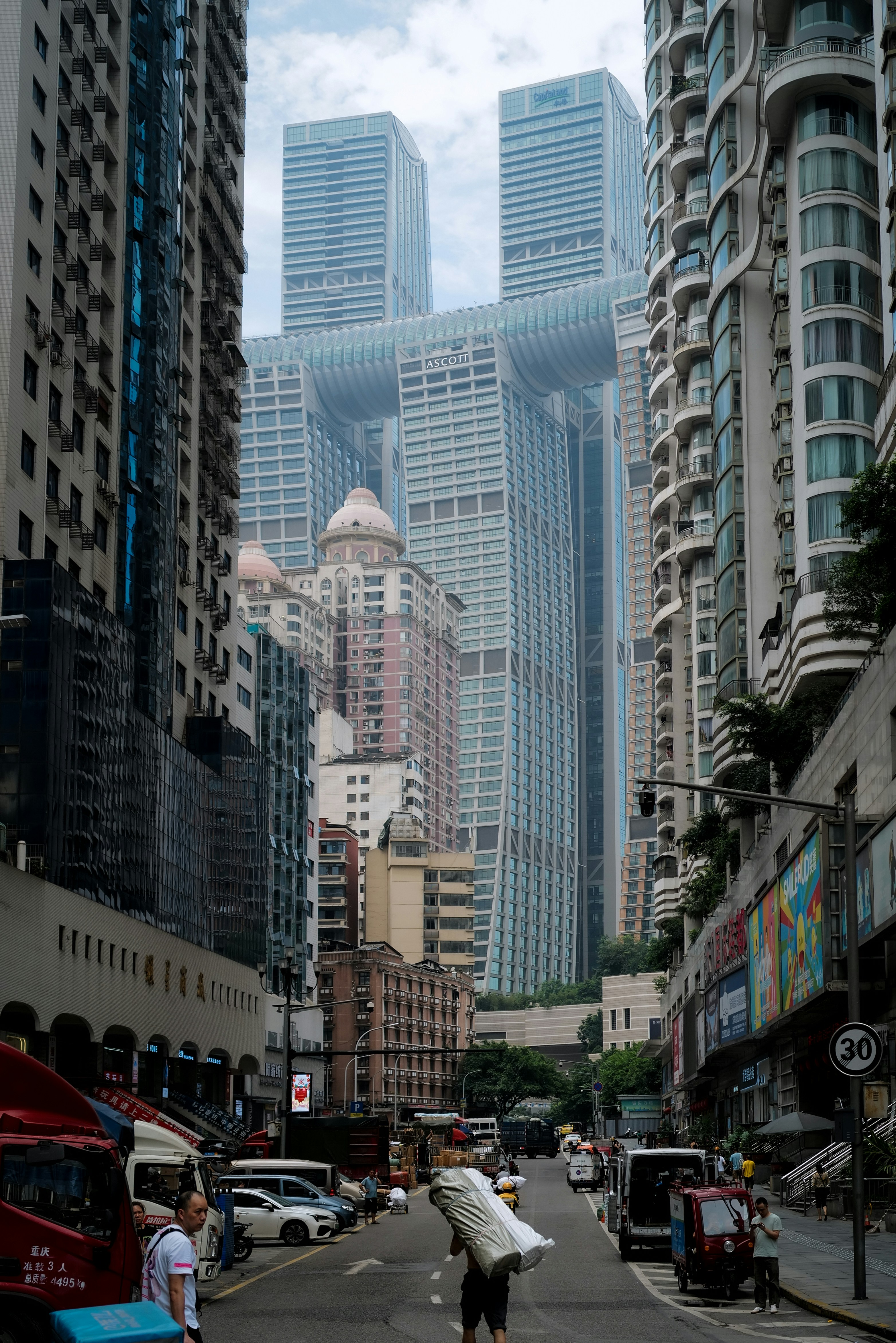 Ein Mann trägt ein Surfbrett eine Straße in der Stadt hinunter