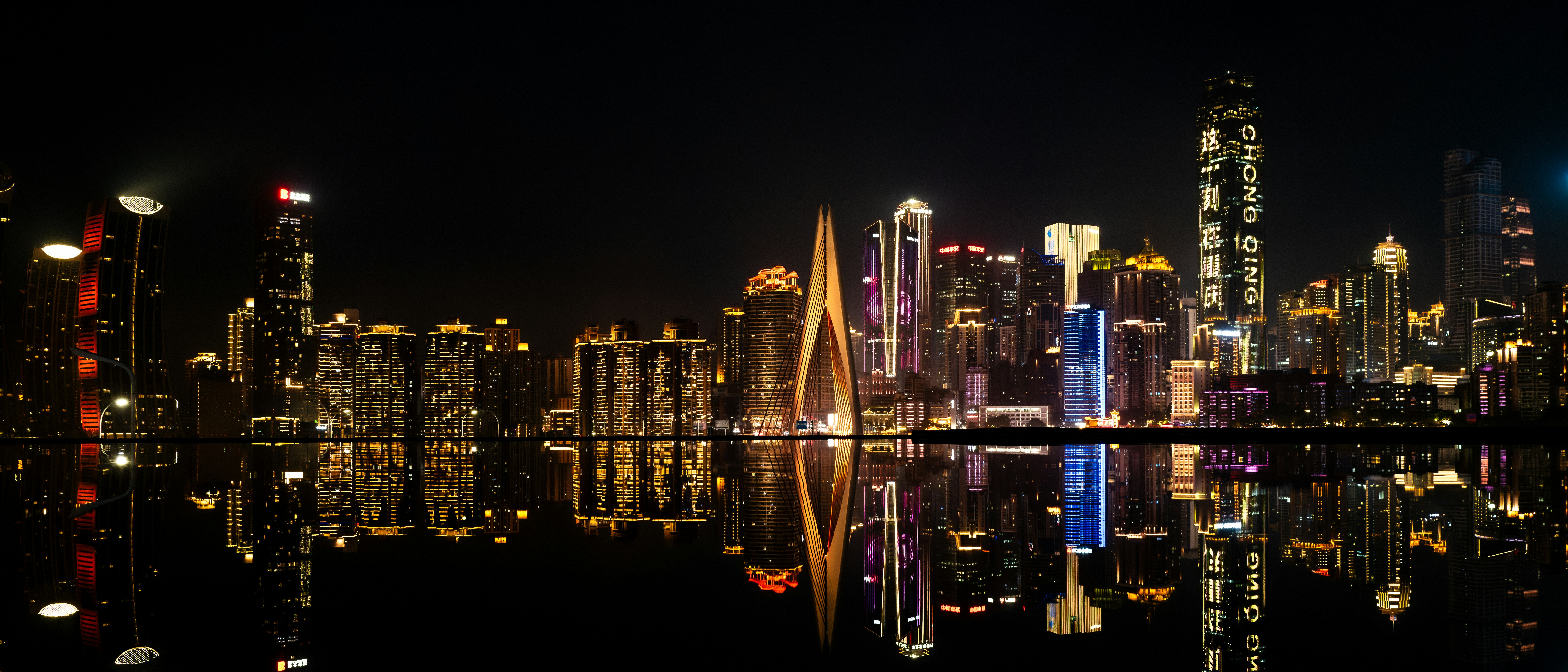 Eine Stadt bei Nacht mit Lichtern, die sich im Wasser spiegeln