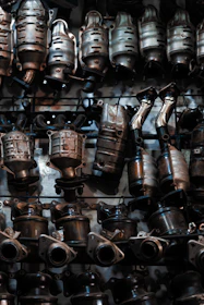 A bunch of metal pots and pans hanging on a wall
