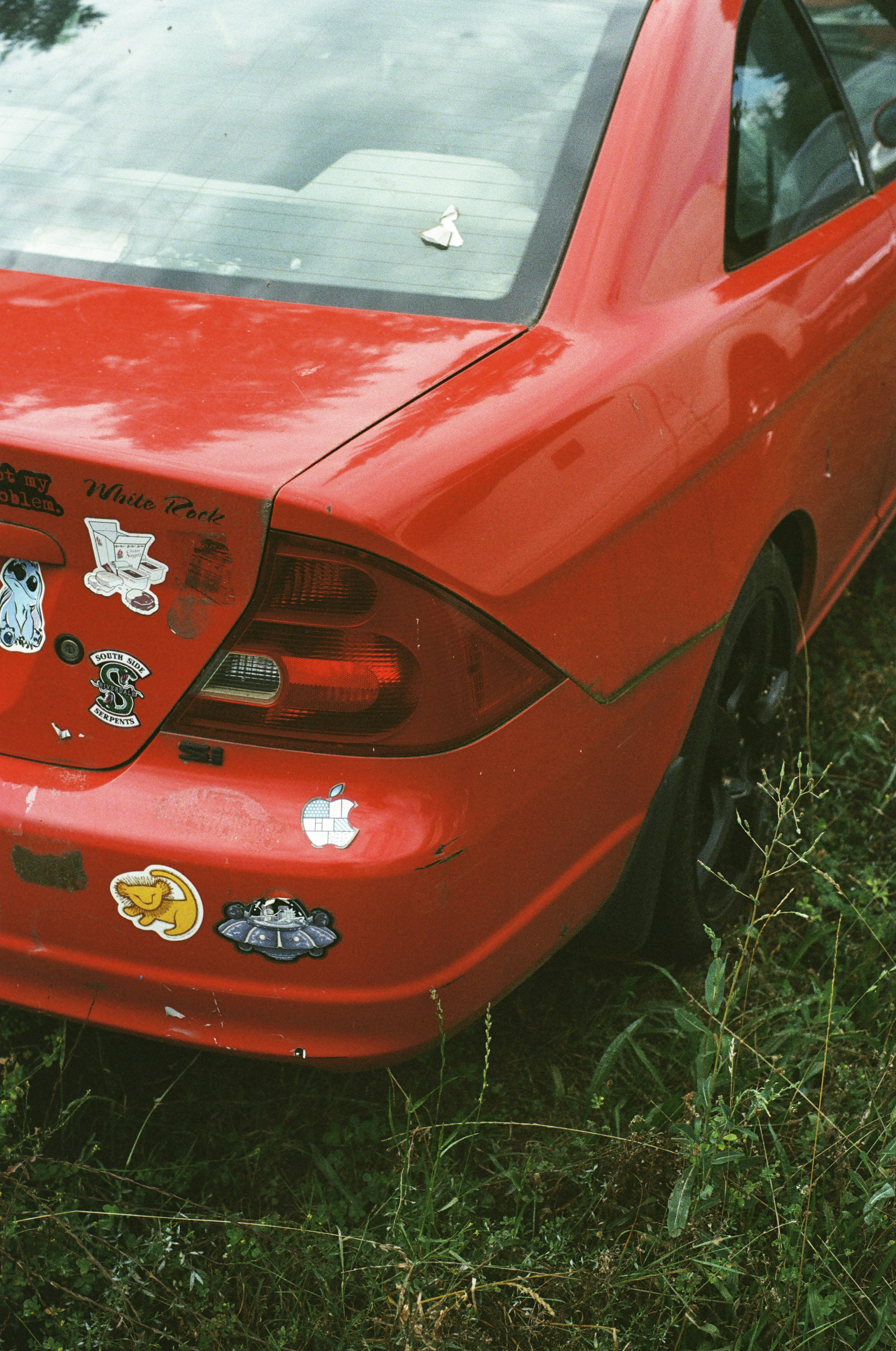 A red car that has stickers on it