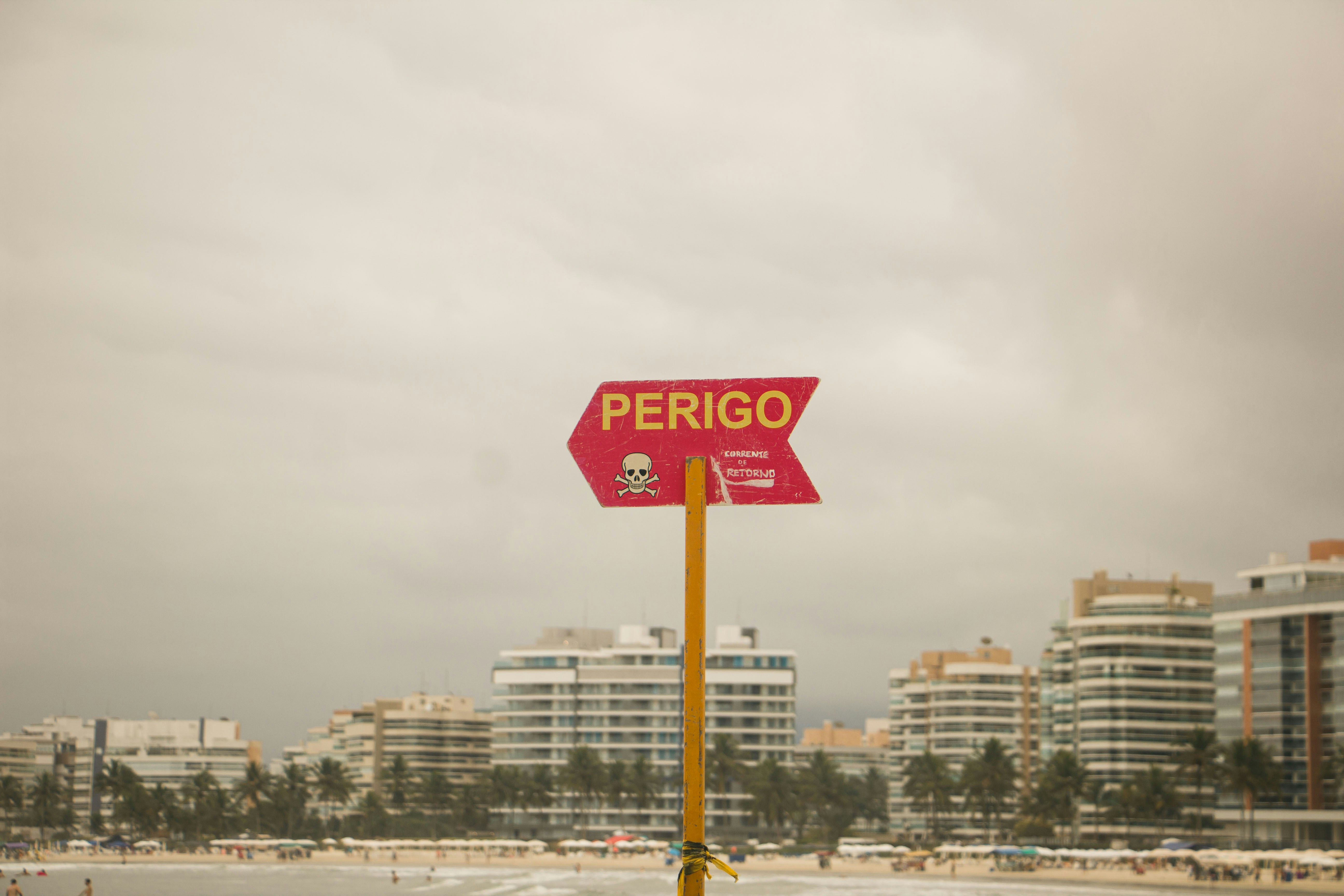 A red street sign sitting on top of a yellow pole