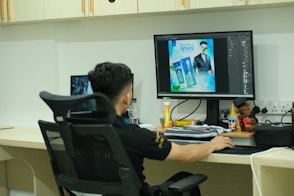A man sitting at a desk in front of a computer monitor