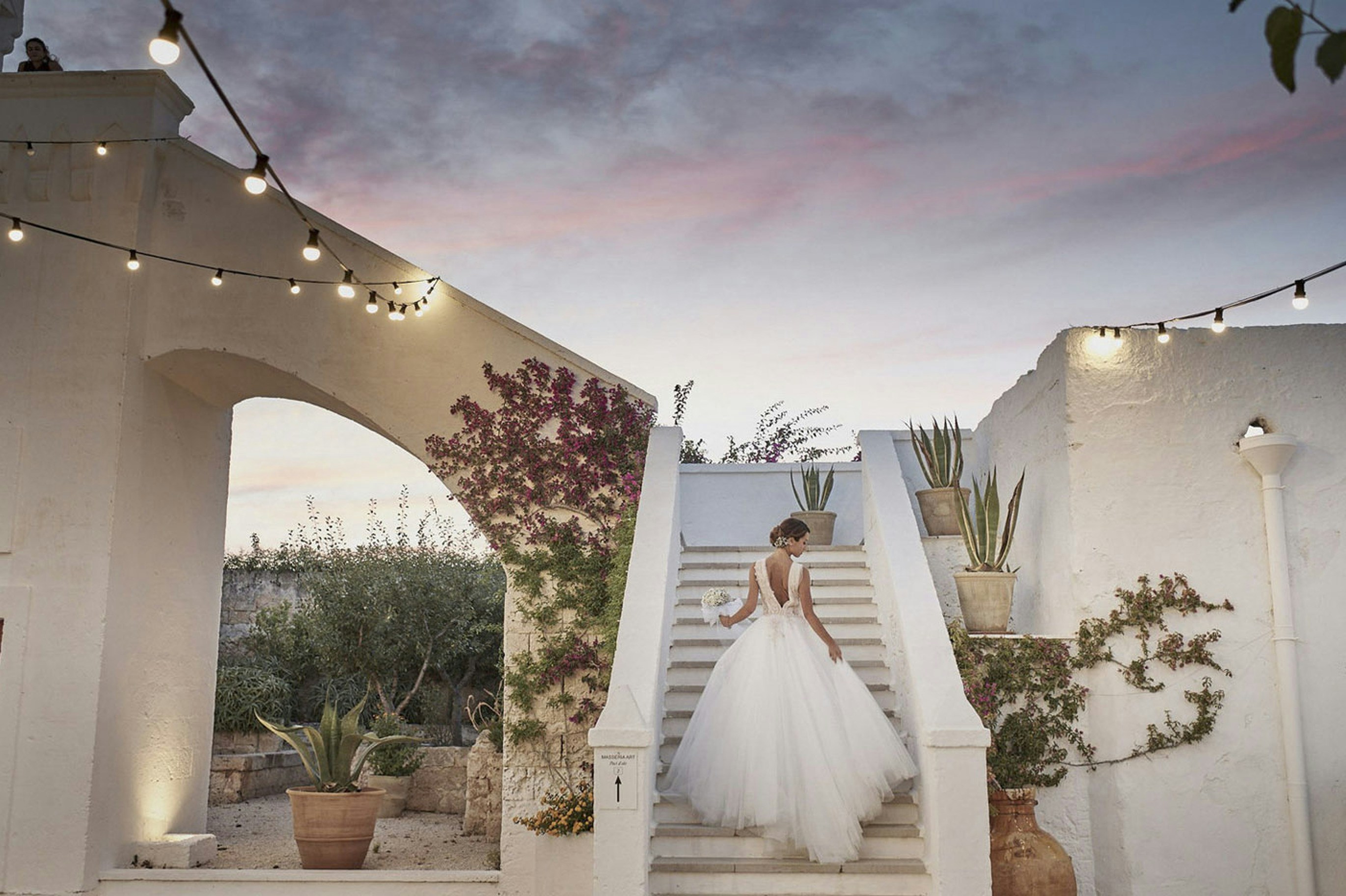 A woman in a wedding dress standing on a set of stairs