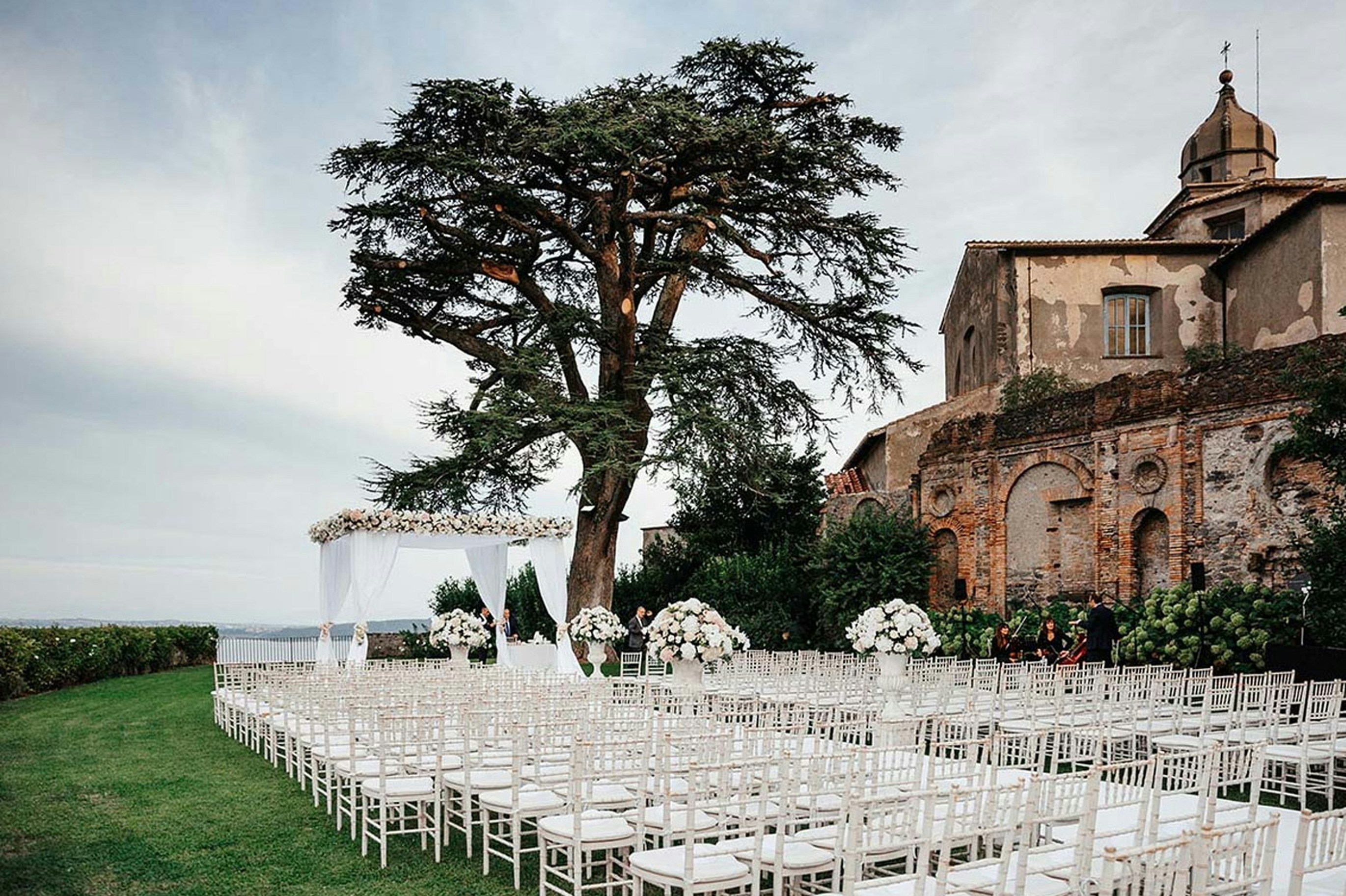 An outdoor ceremony setup with white chairs
