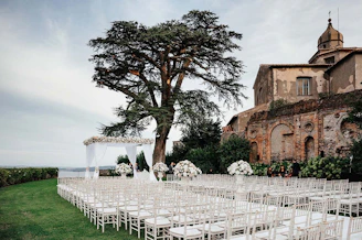 An outdoor ceremony setup with white chairs