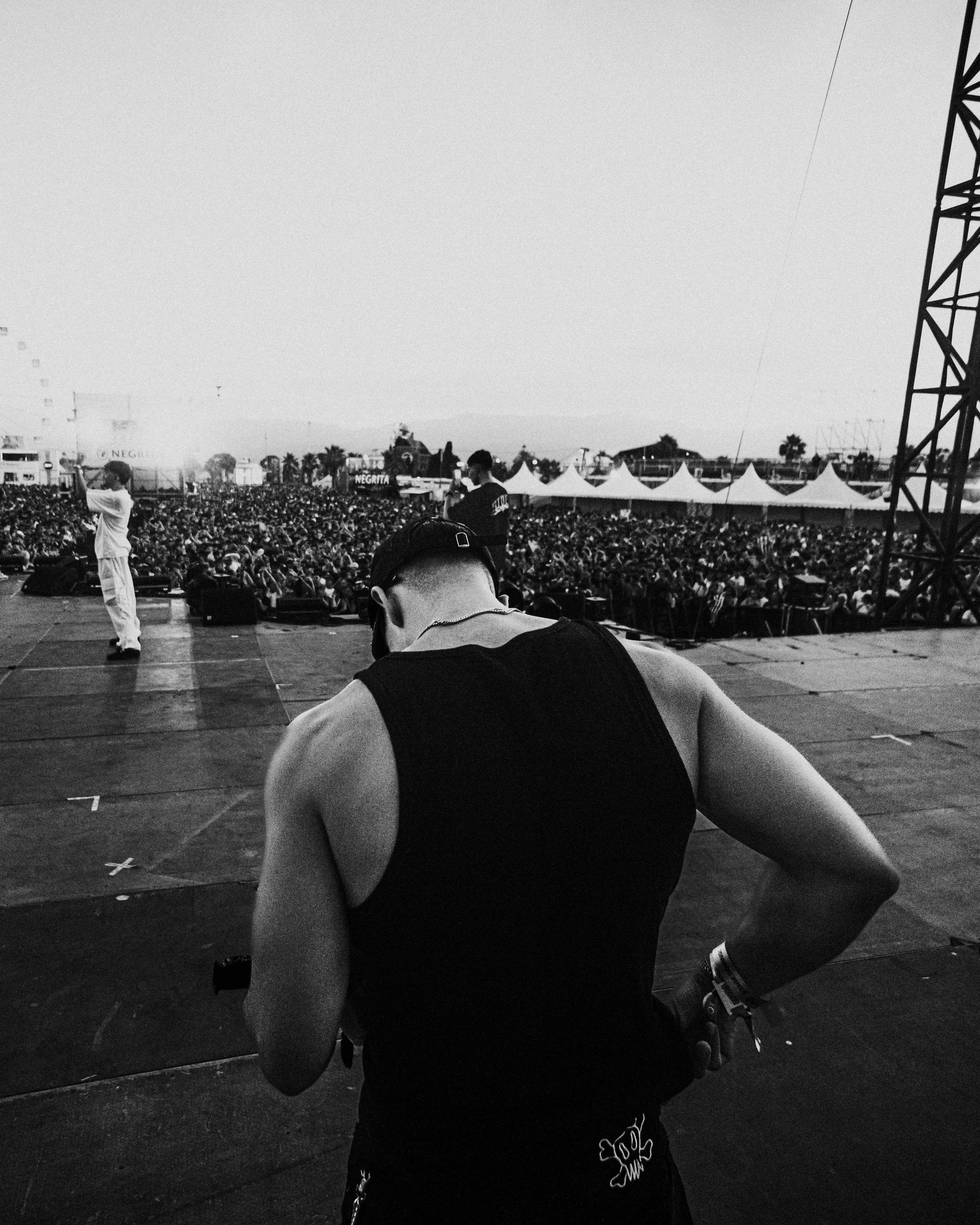 A man standing on top of a stage next to a crowd