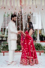 A man and woman standing under a canopy of flowers